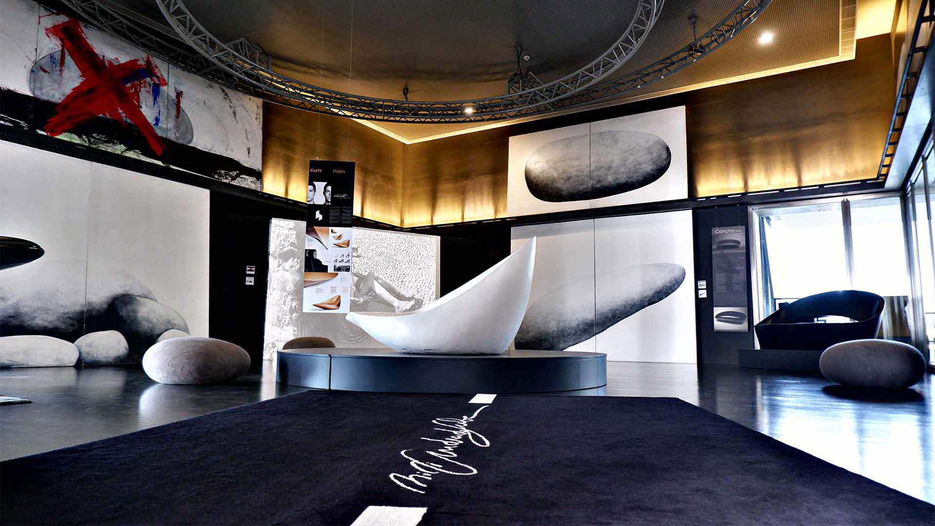 Espaço decorativo com calhau grande e quadros nas paredes.