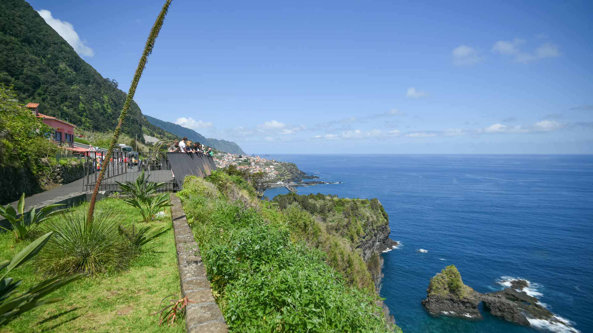 Personas en mirador con vista al mar y vegetación en Madeira.