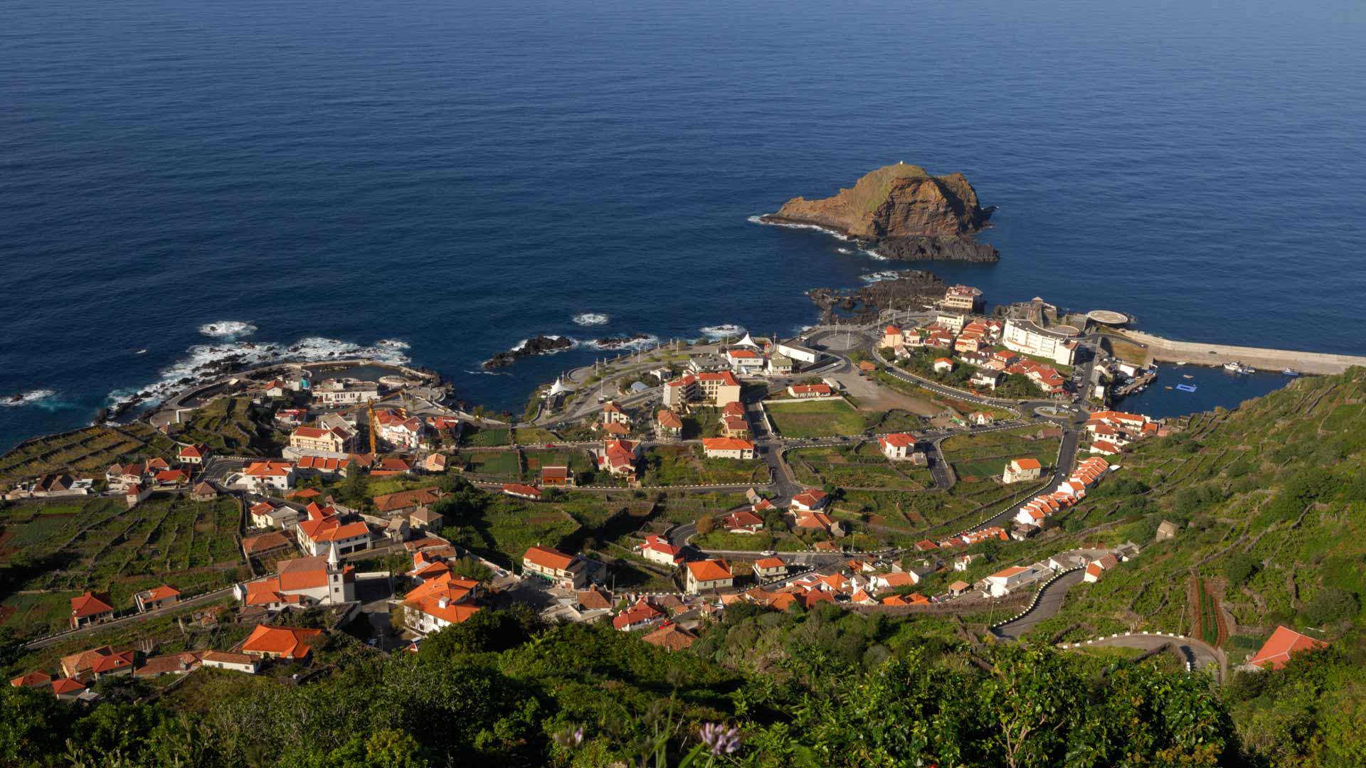 Maisons sur la pente avec vue sur la mer et formation rocheuse à Madère.