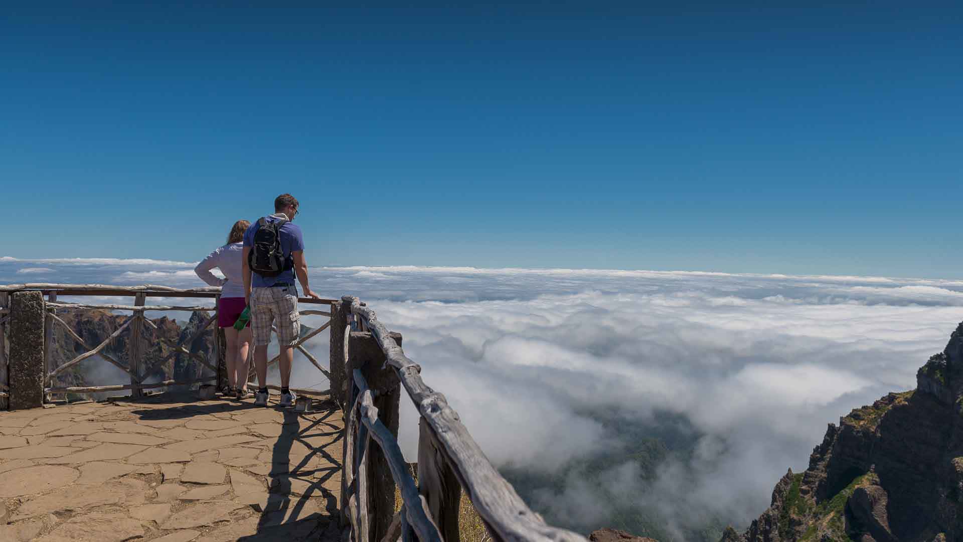 Couple at viewpoint with clouds in Madeira.