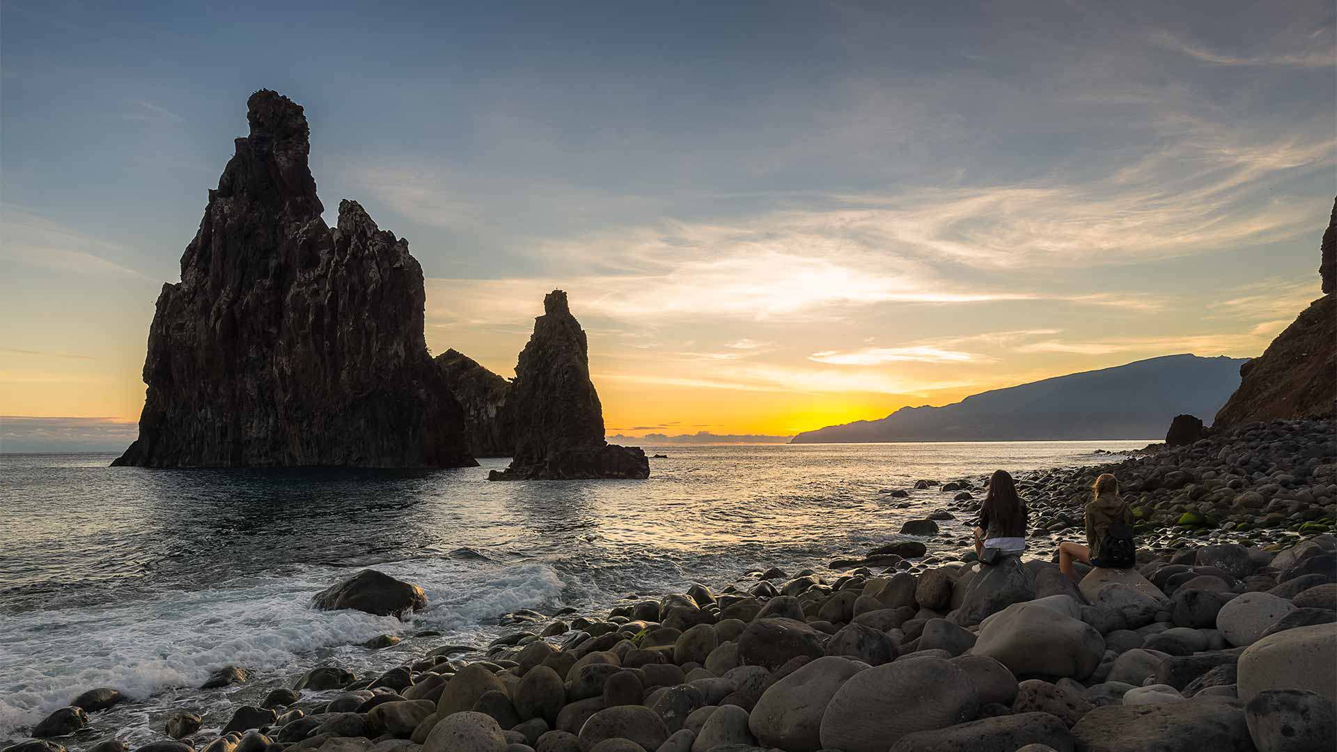 Rock formation in the sea at sunset, surrounded by stones, in Madeir