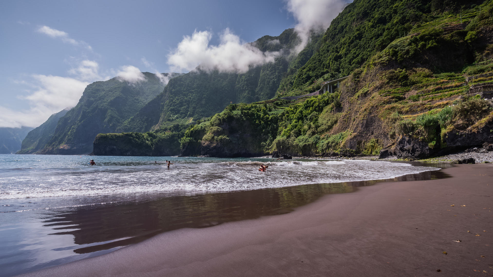 Schwarzer Sandstrand am Meer und Berg auf Madeira.