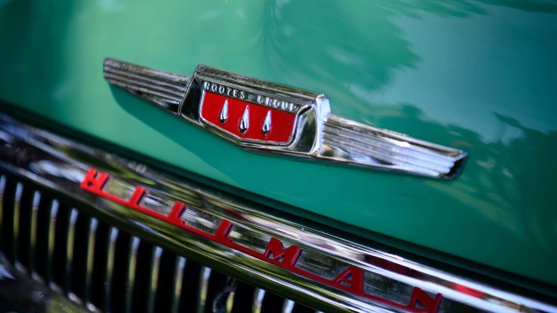 Voiture classique de la marque Hillman, aux couleurs verte et rouge.