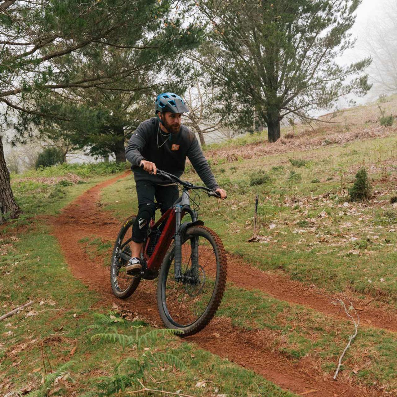 Mann fährt Mountainbike auf einem Naturpfad.