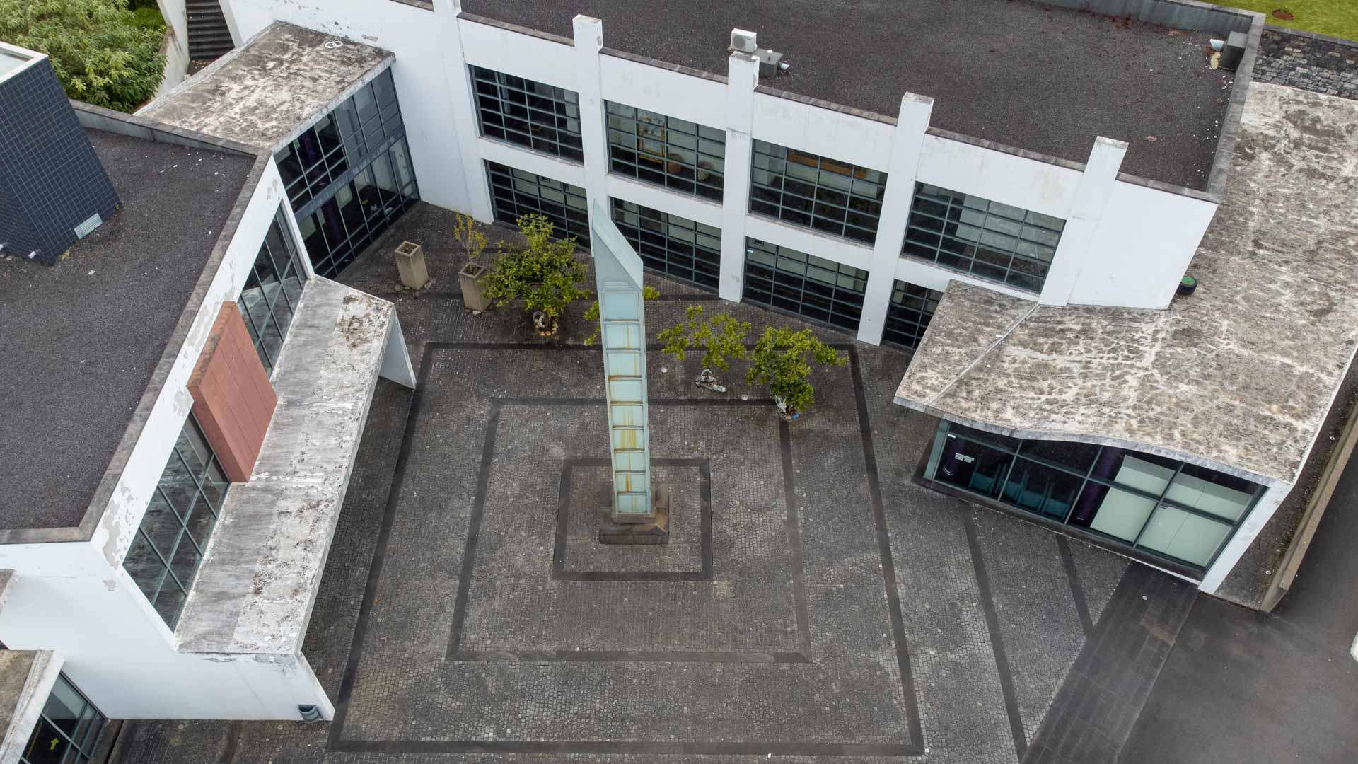 Glass buildings with stone flooring seen from above.