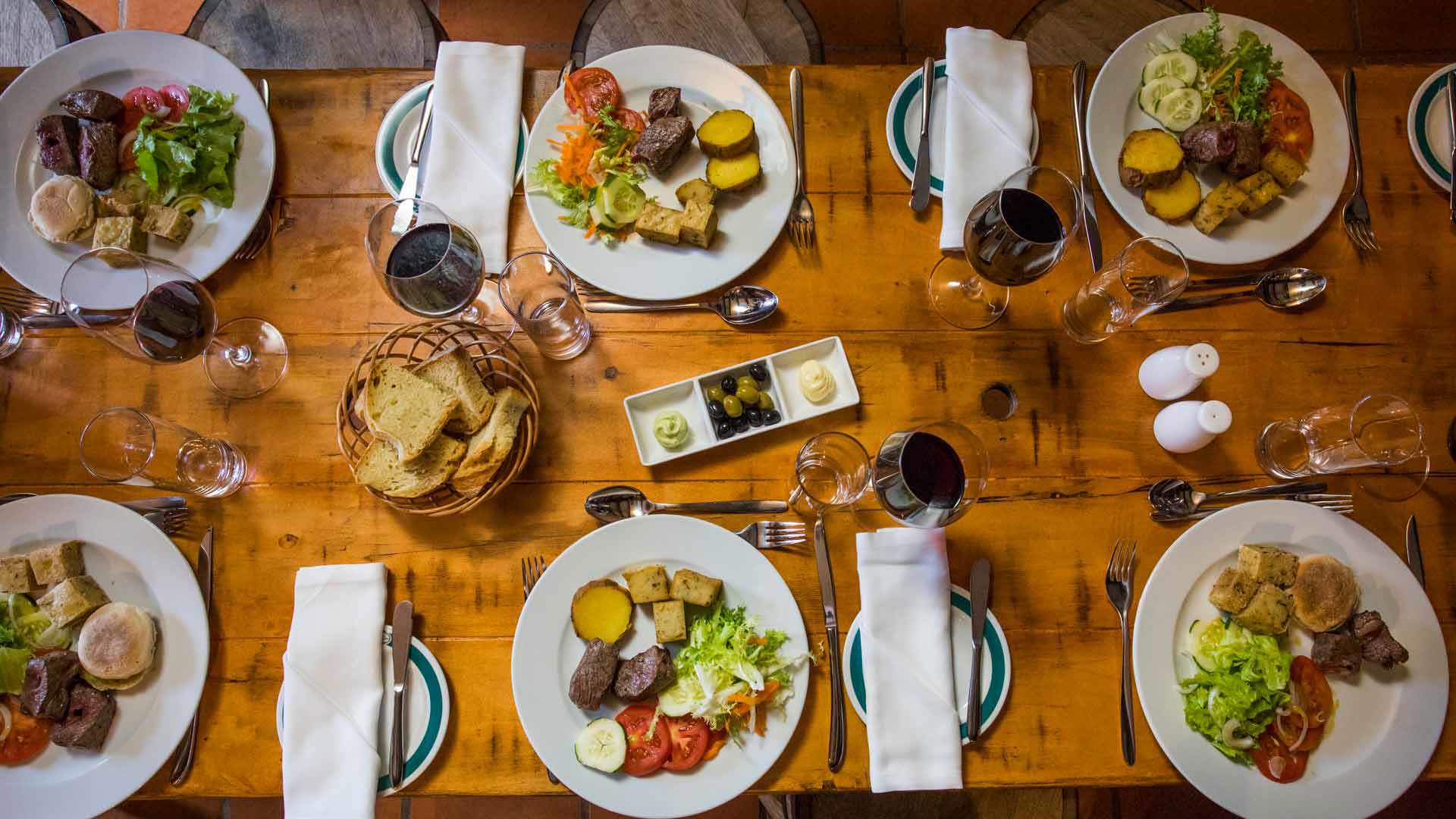 Mesa preparada con platos y copas de vino para una comida en la isla de Madeira.