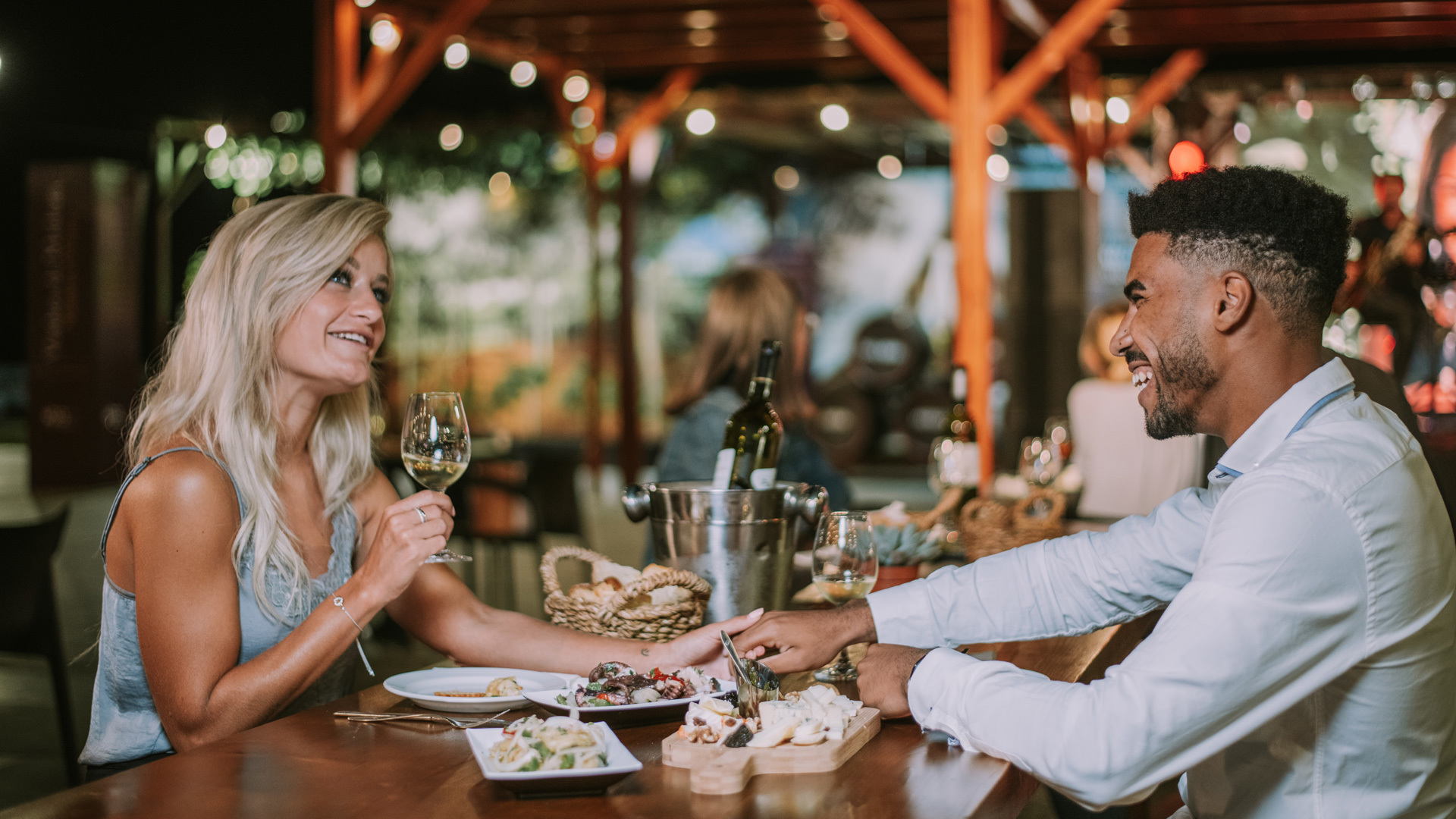 Couple talking while enjoying a meal accompanied by wine on Madeira Island.