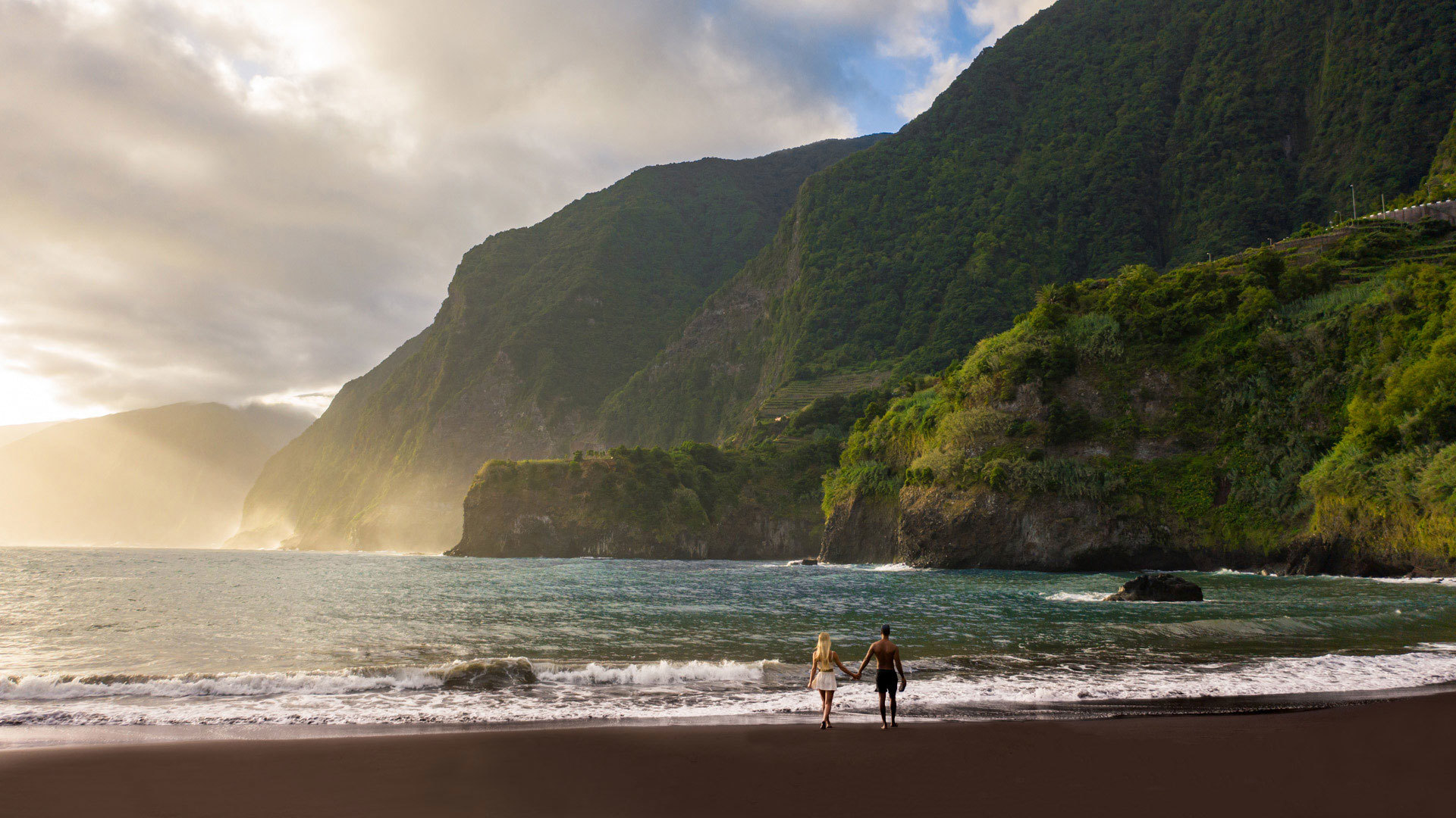 Pareja en la playa de Seixal, en la costa norte de Madeira, junto al mar.