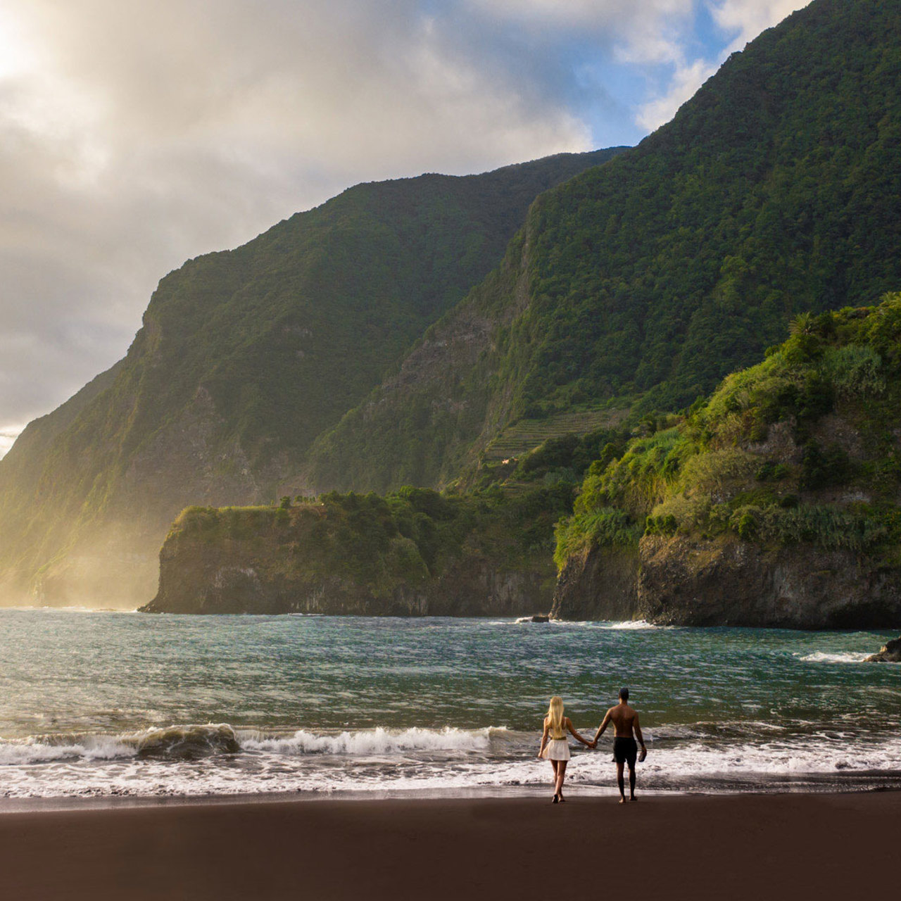 Casal na praia do Seixal, na costa norte da Madeira, junto ao mar.