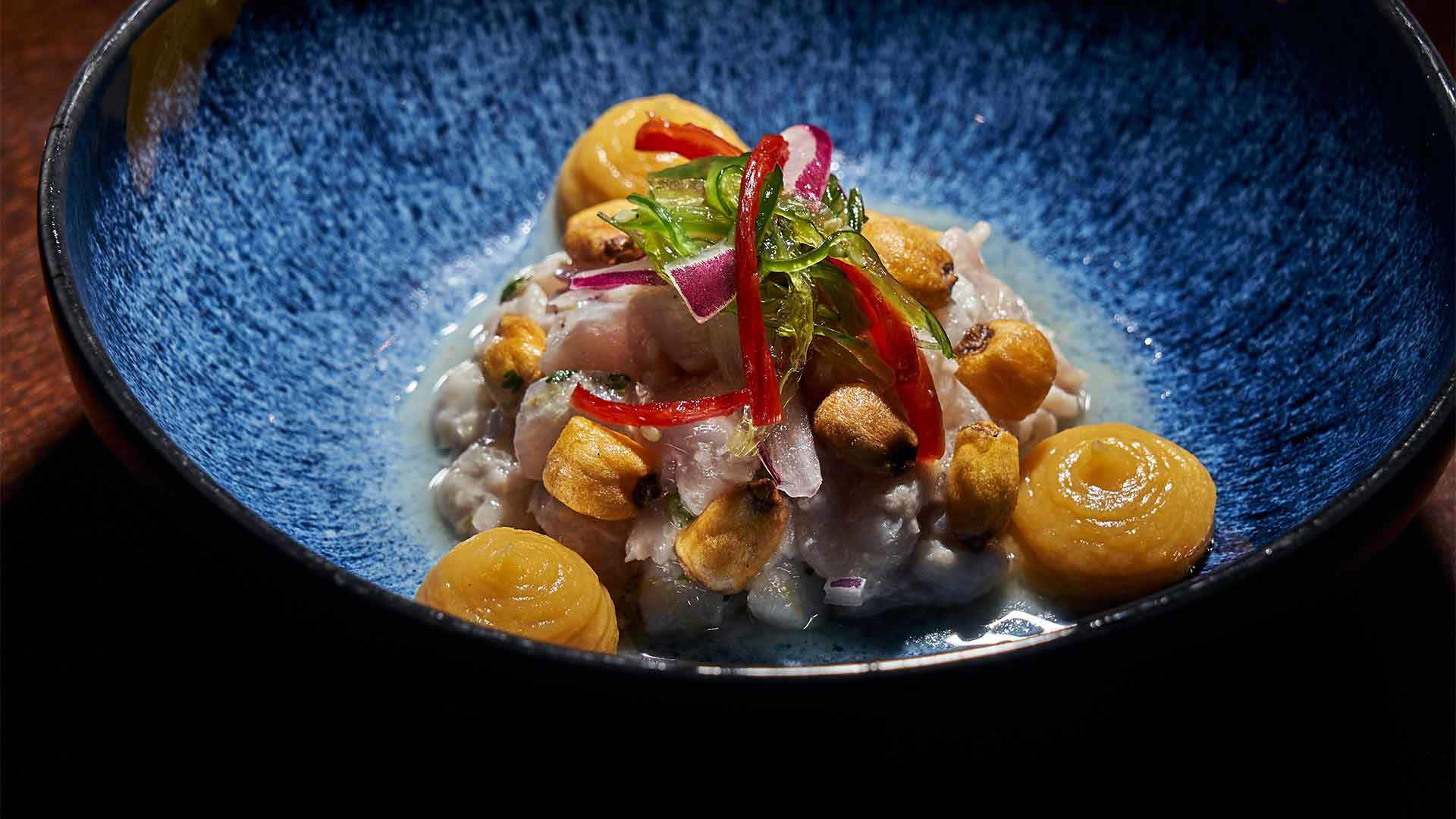 Assiette creuse avec poisson et sauce jaune.