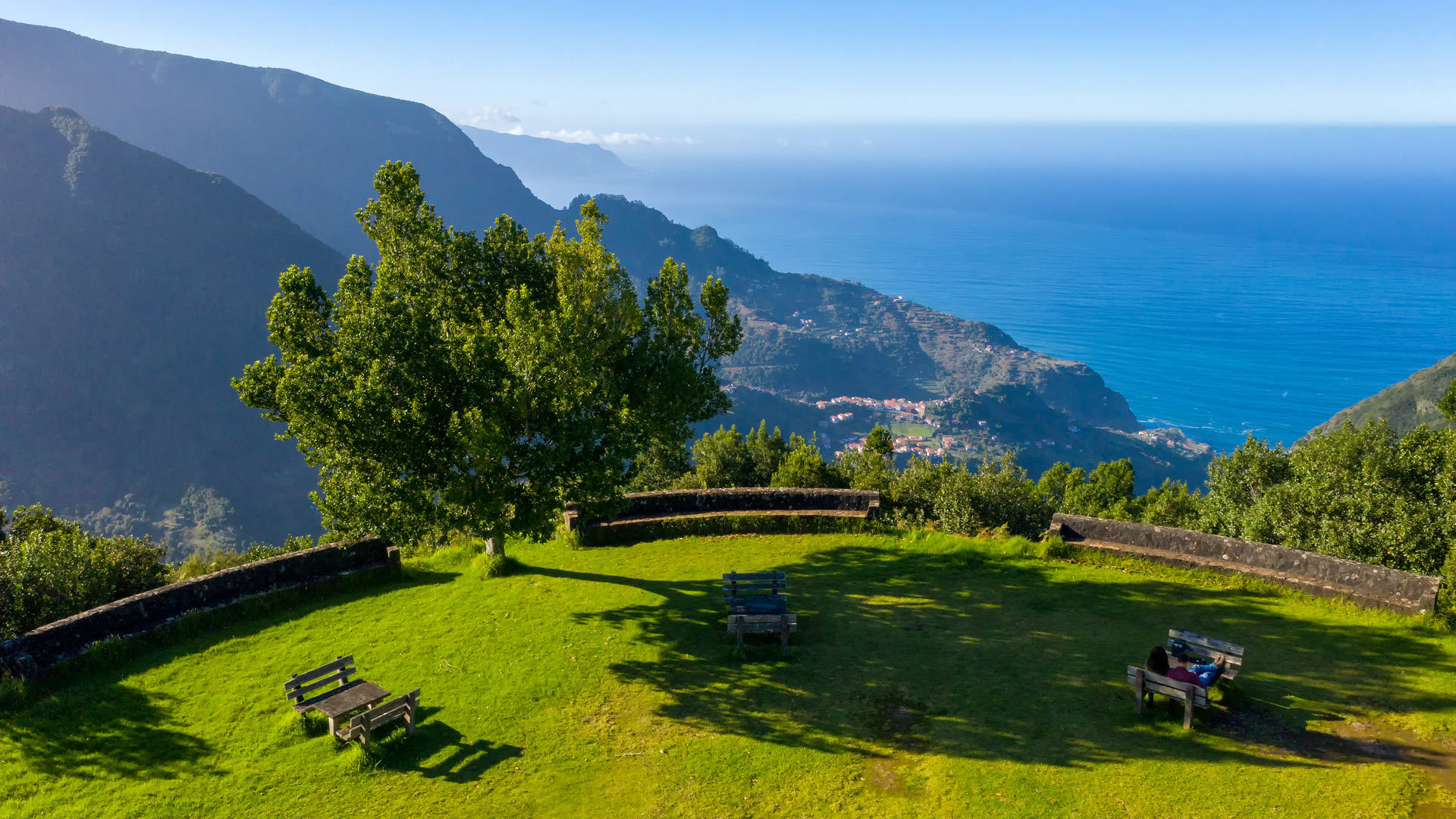 Garden with picnic benches and sea view in Madeira.
