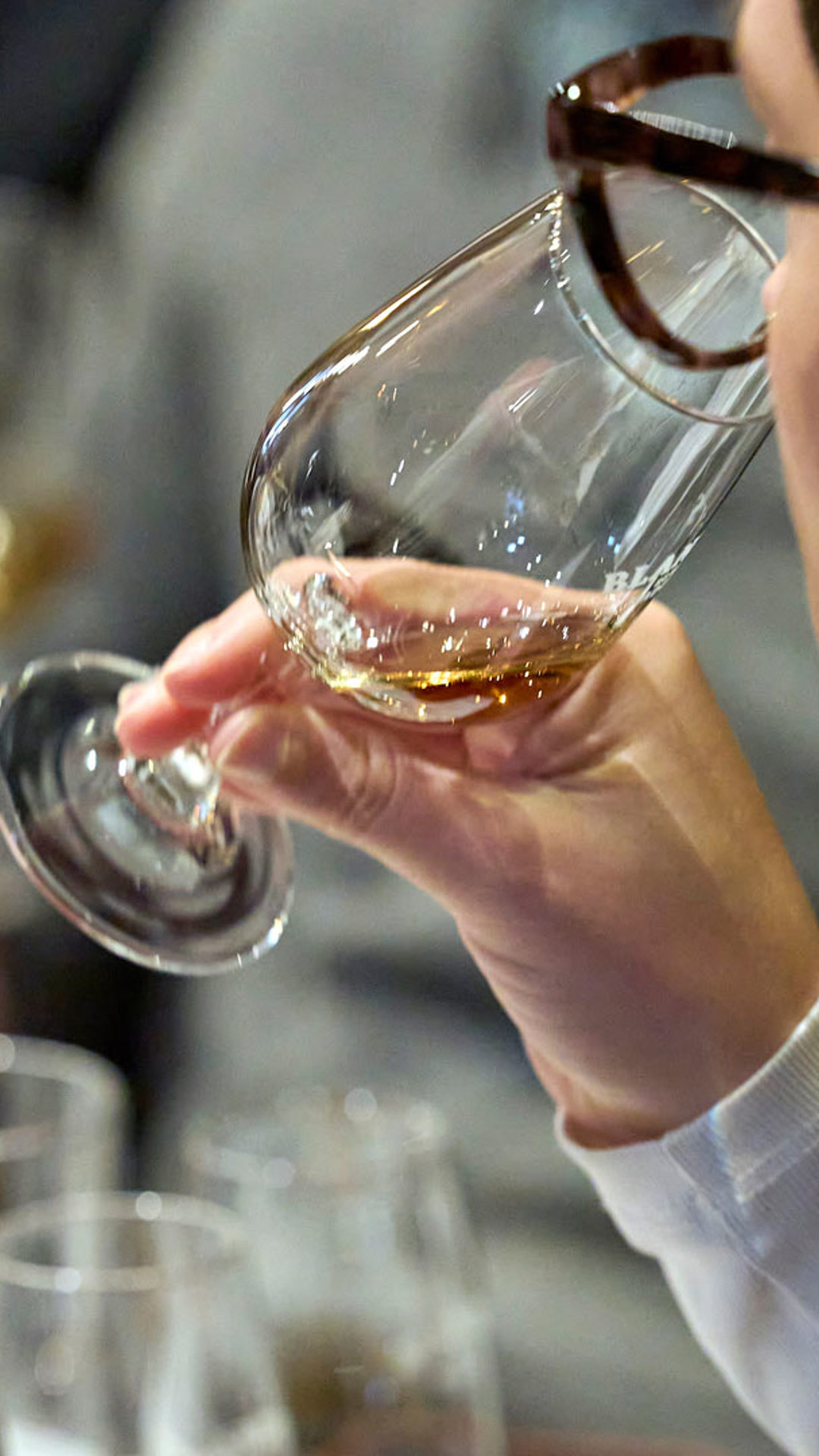 Hand holding a glass during Madeira wine tasting.