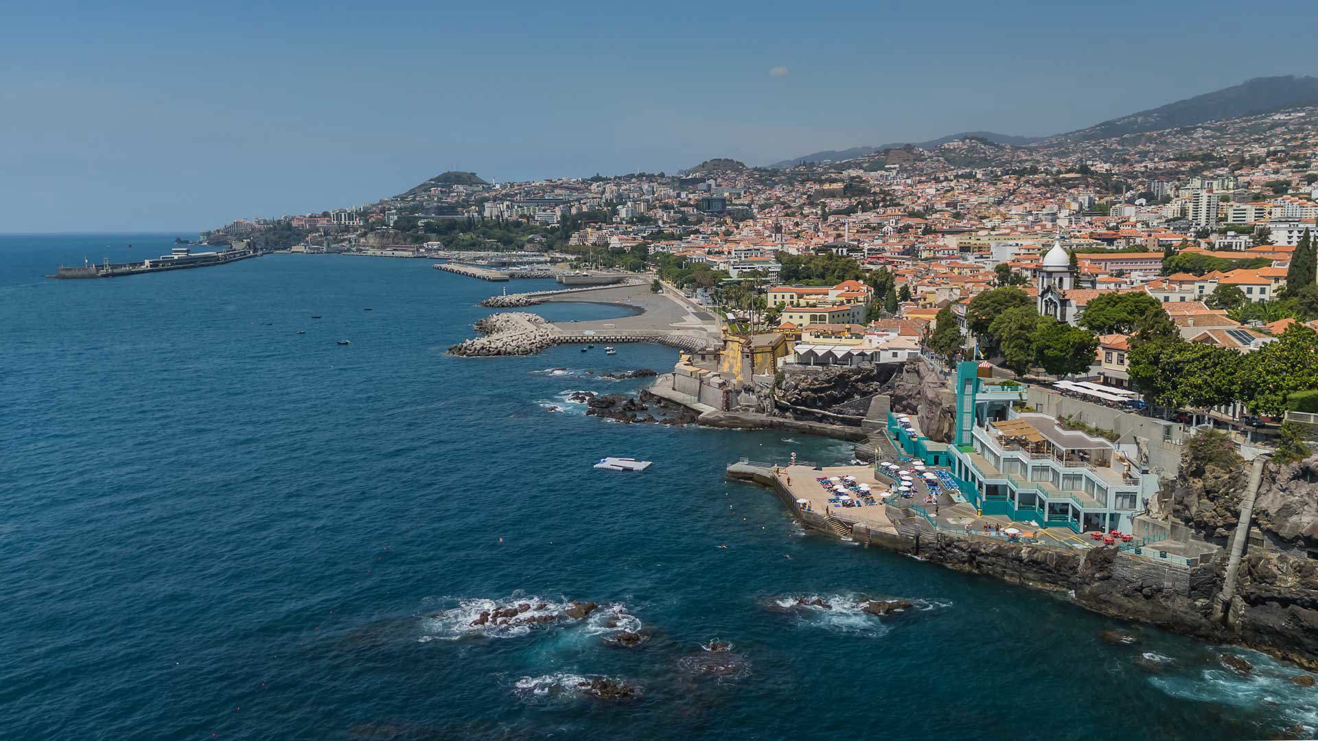 Baie avec mer et maisons côtières le long du rivage.