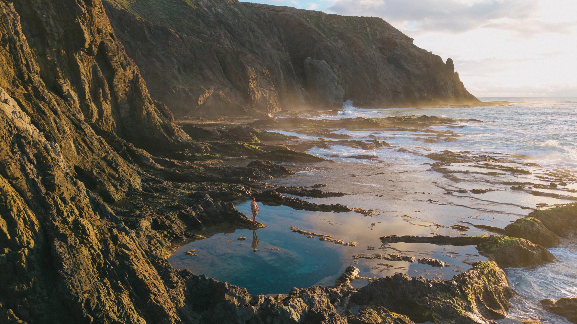 Mann in den natürlichen Felsenpools am Strand von Salemas, auf Porto Santo.