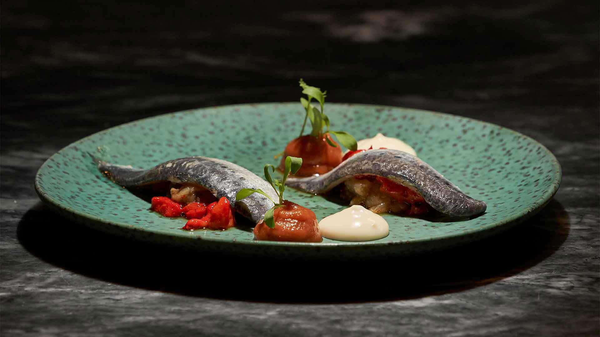 Fischgericht mit Soßen und Paprika.