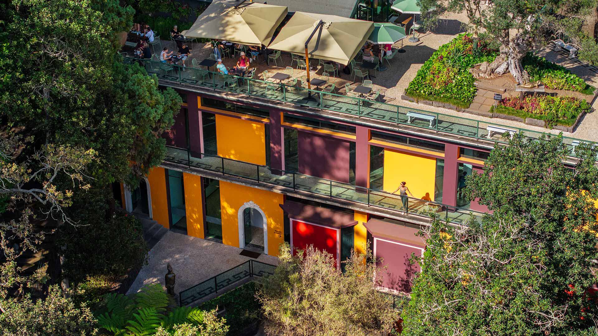 Pabellón exterior del Museo Monte Palace con paredes coloridas y rodeado de vegetación.