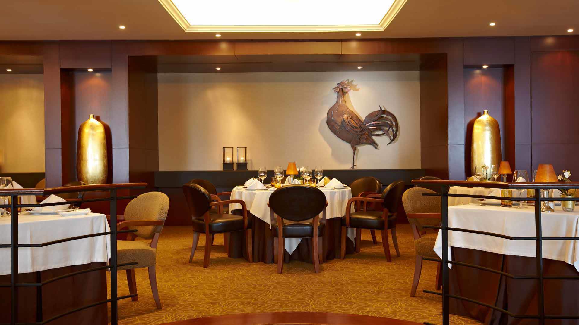 Restaurantzimmer mit Tischen und Stühlen, spezialisiert auf zeitgenössische Küche.