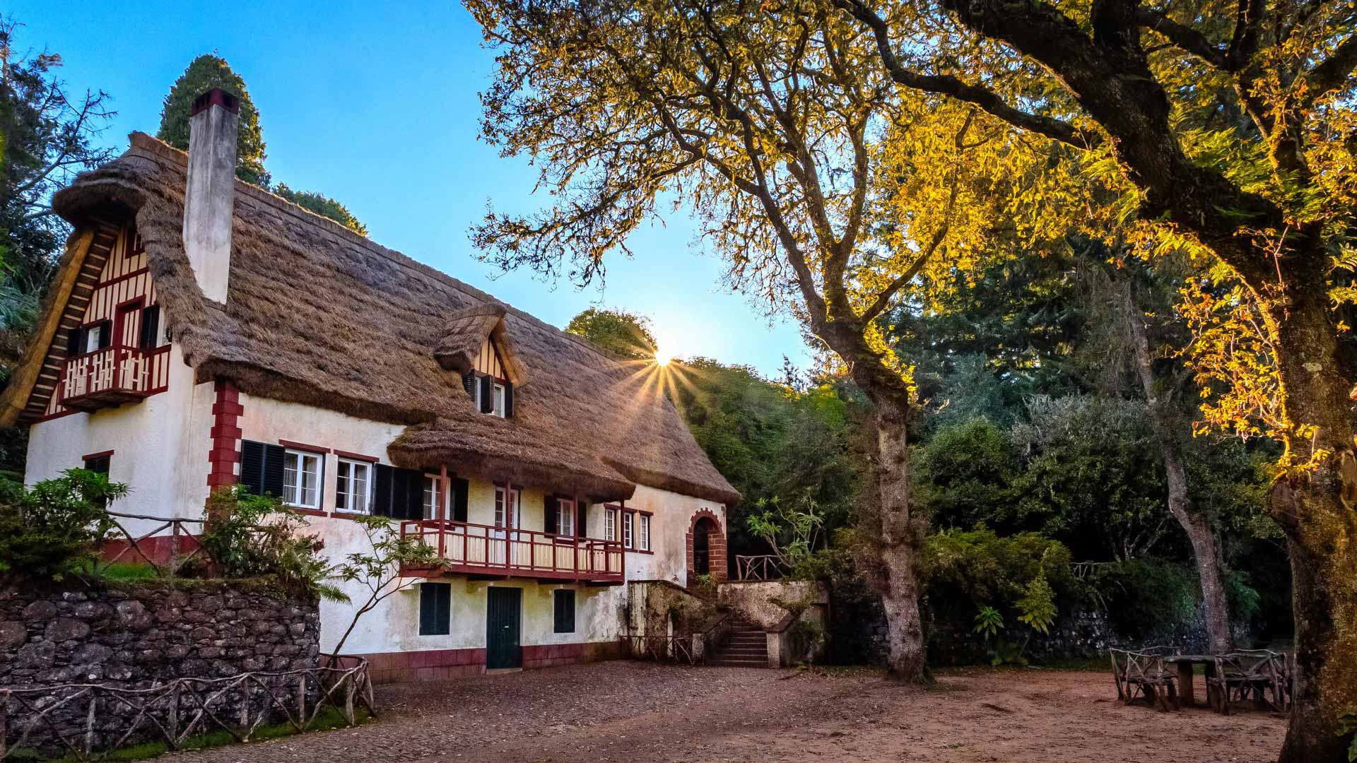 Casa con tejado triangular entre árboles y naturaleza en Madeira.
