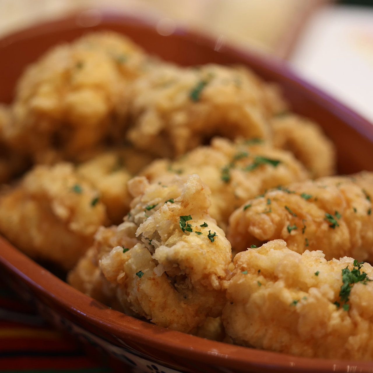 Espada frita servida num prato com salsa por cima.