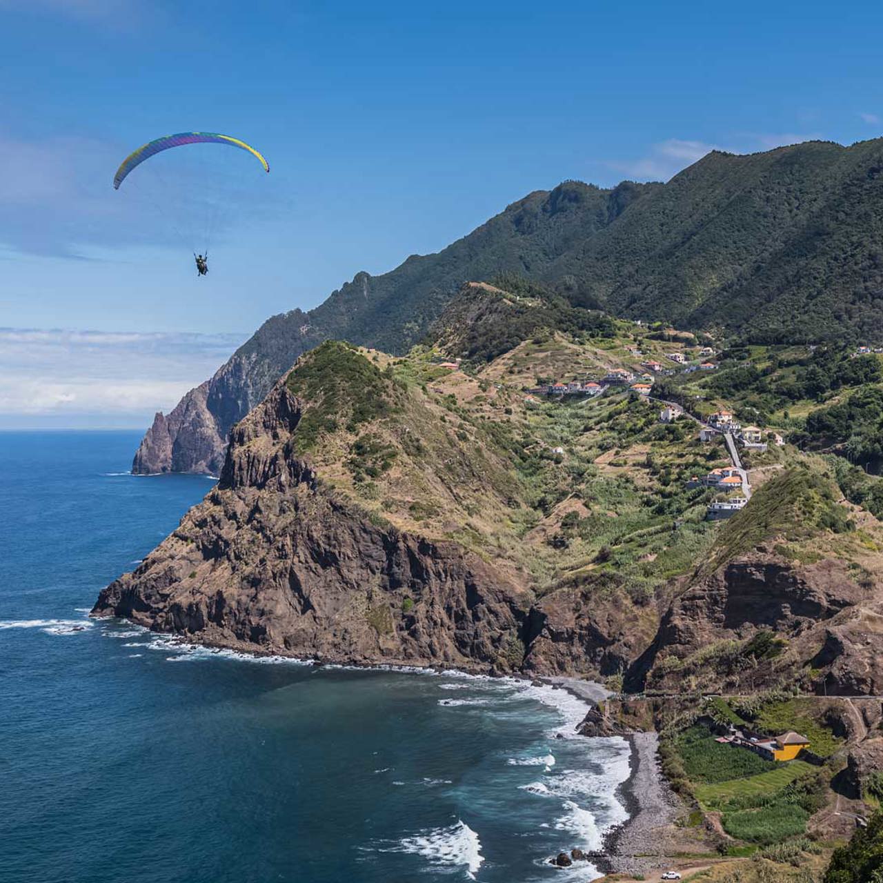 Paragliding over the sea with mountains in the background