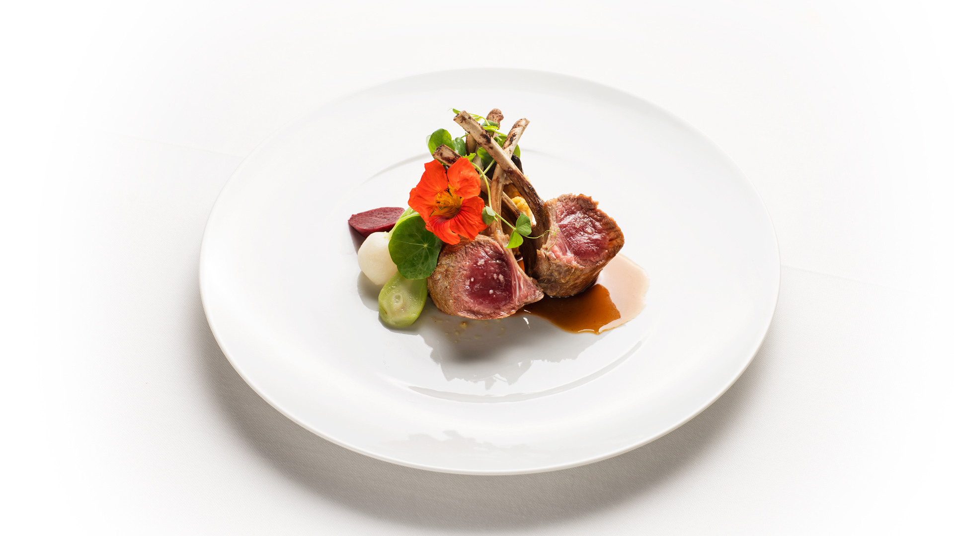 Teller mit Fleischgericht und grünen Gemüsen.