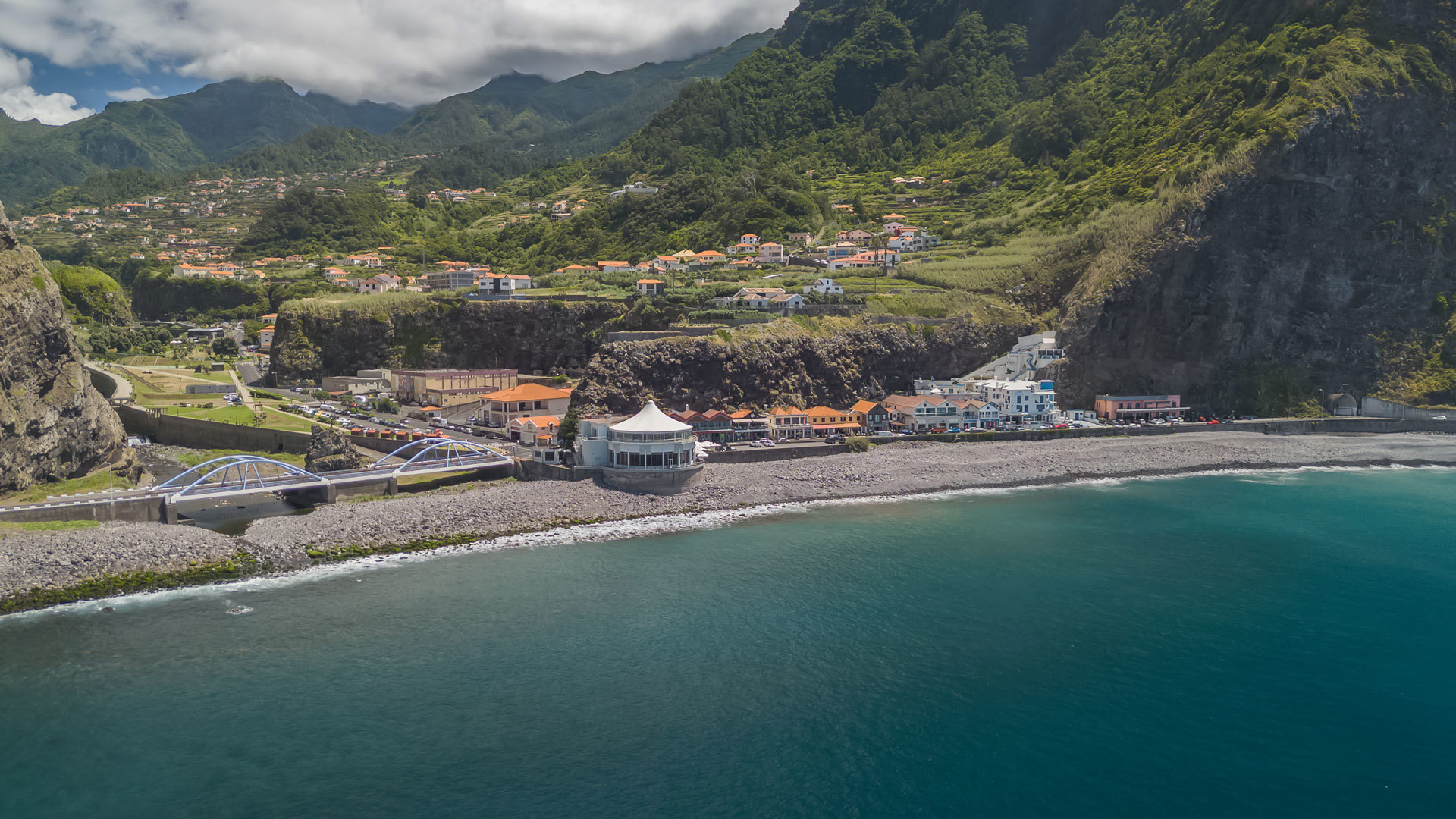 Casas no vale com mar e nuvens na Madeira.