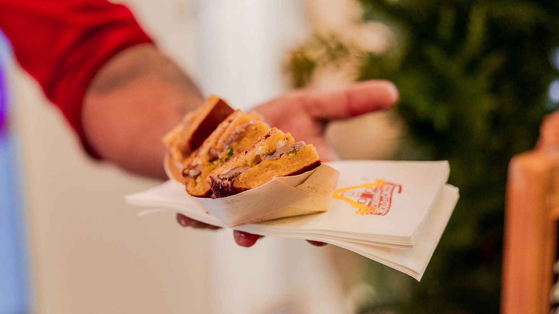Hand holding bolo do caco with garlic butter at the Madeira Tourism Office in Lisbon.