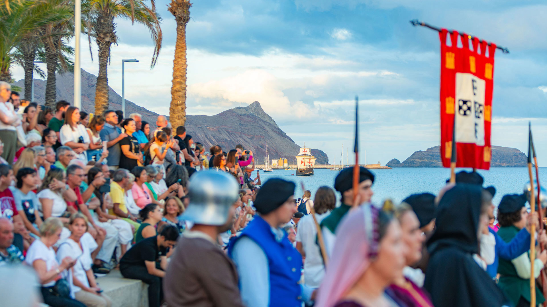 Spectateurs au Festival de Colombo à Porto Santo regardant une nef en mer.