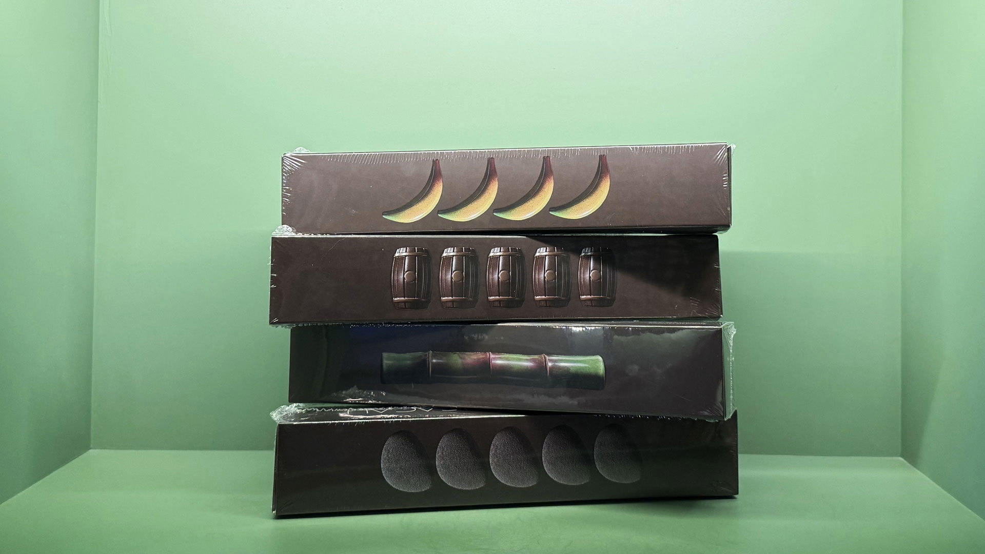 Four boxes of UAU Cacau chocolates displayed on a shelf.
