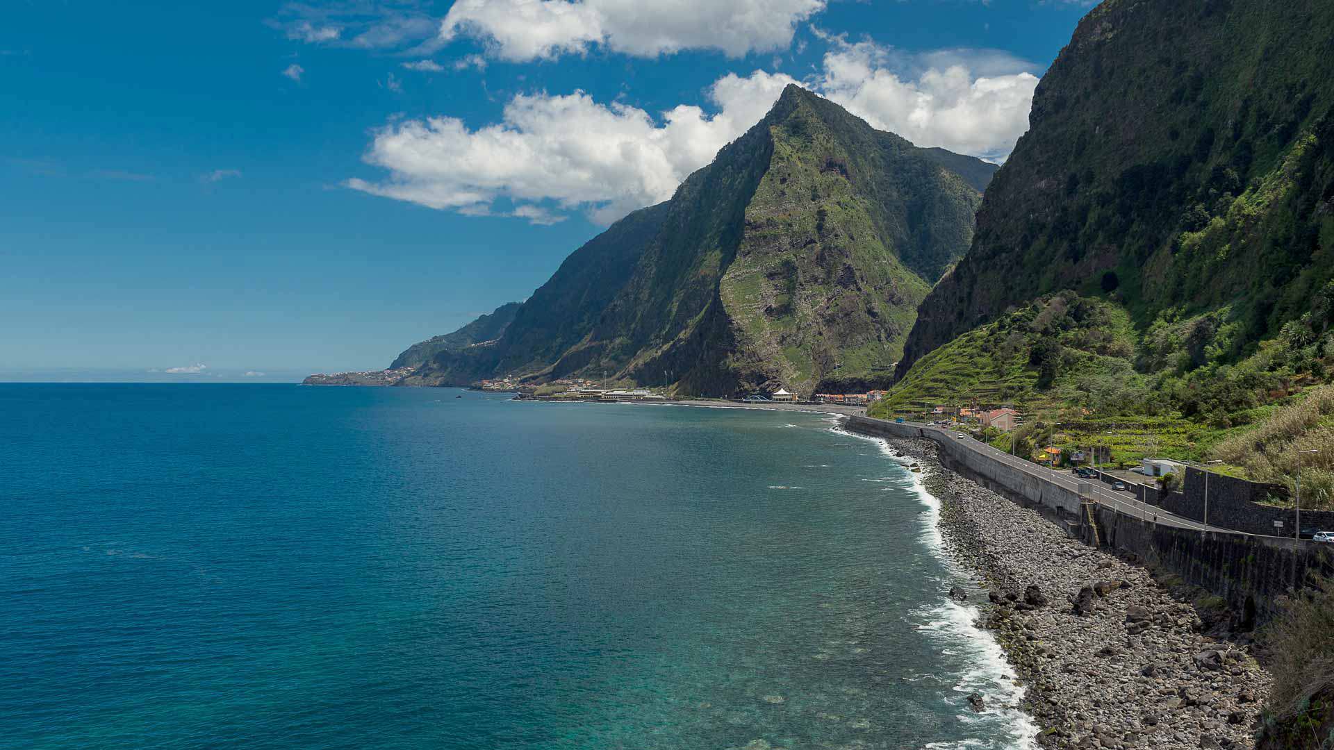 Meer mit Kiesstrand und Bergen auf Madeira.