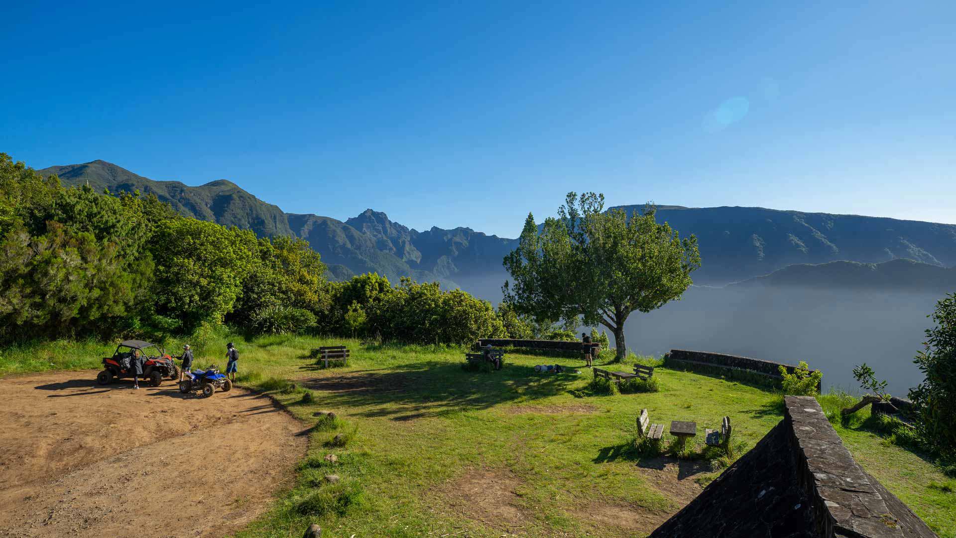 Garten mit Bänken, Personen und Blick auf die Berge auf Madeira.