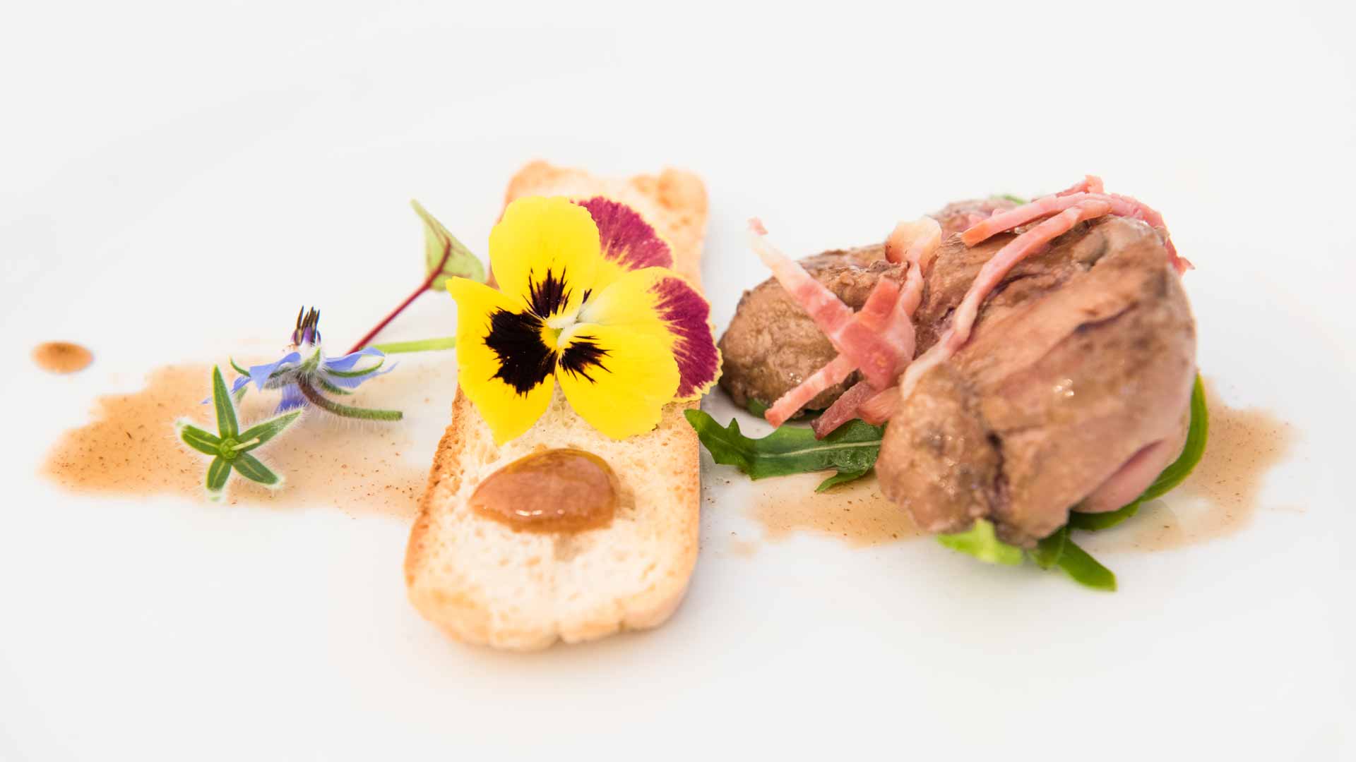 Plato de carne emplatado en plato blanco al estilo de gastronomía contemporánea.