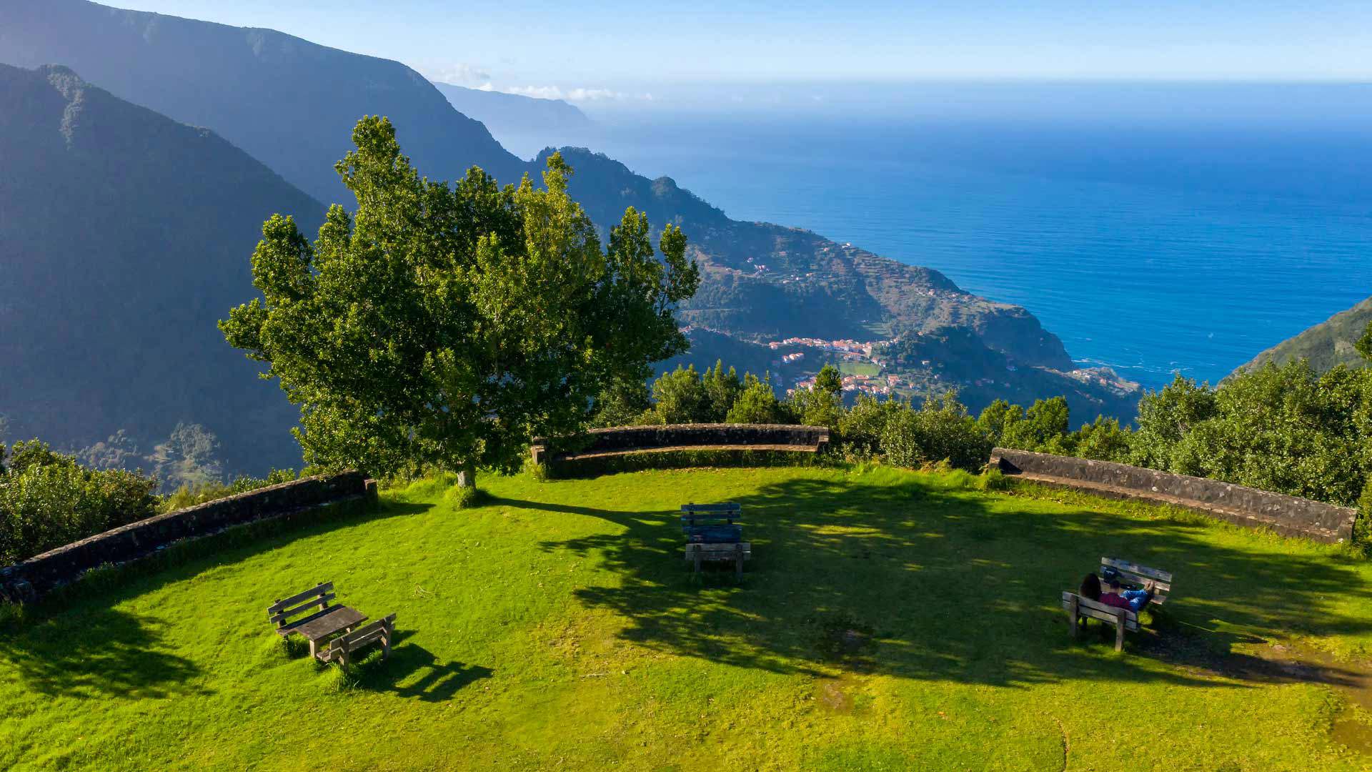 Garten mit Picknickbänken und Meerblick auf Madeira.