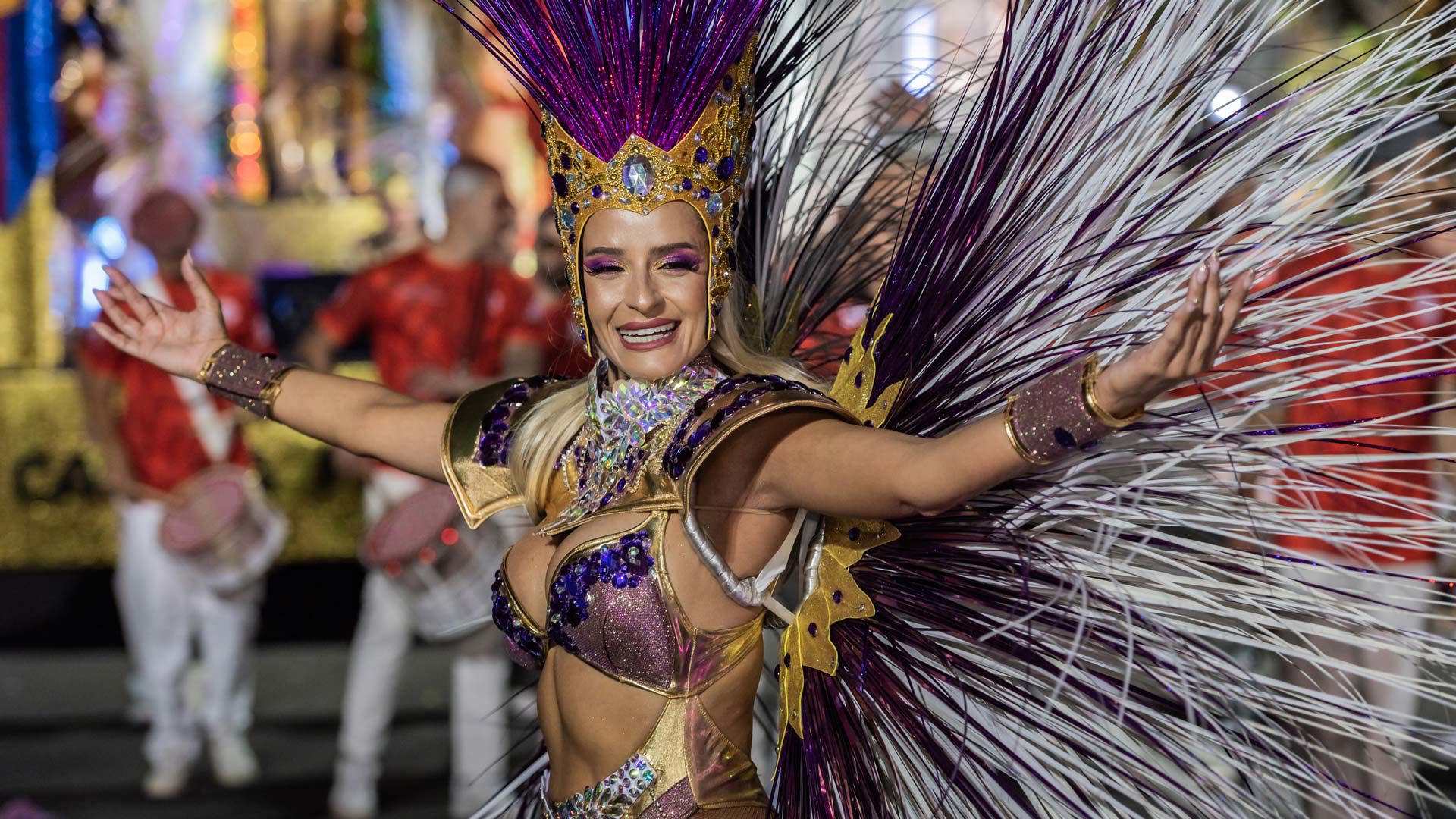 Woman in costume taking part in a Carnival parade at night in Funchal, Madeira.
