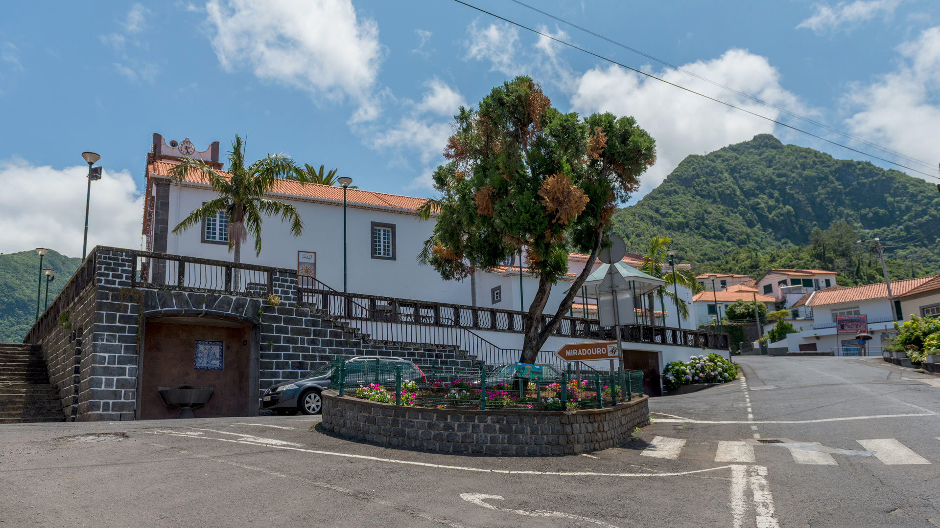 Carretera con casas y montaña al fondo.