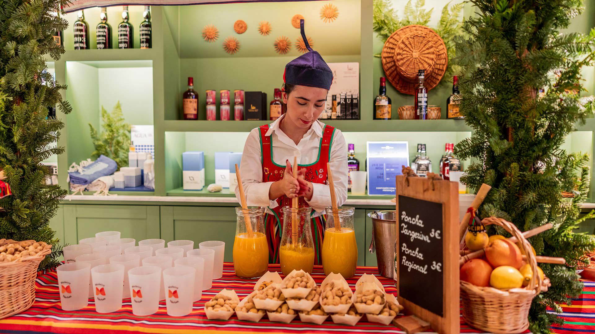 Event at the Madeira Tourism Office in Lisbon with a poncha stall and a woman serving.