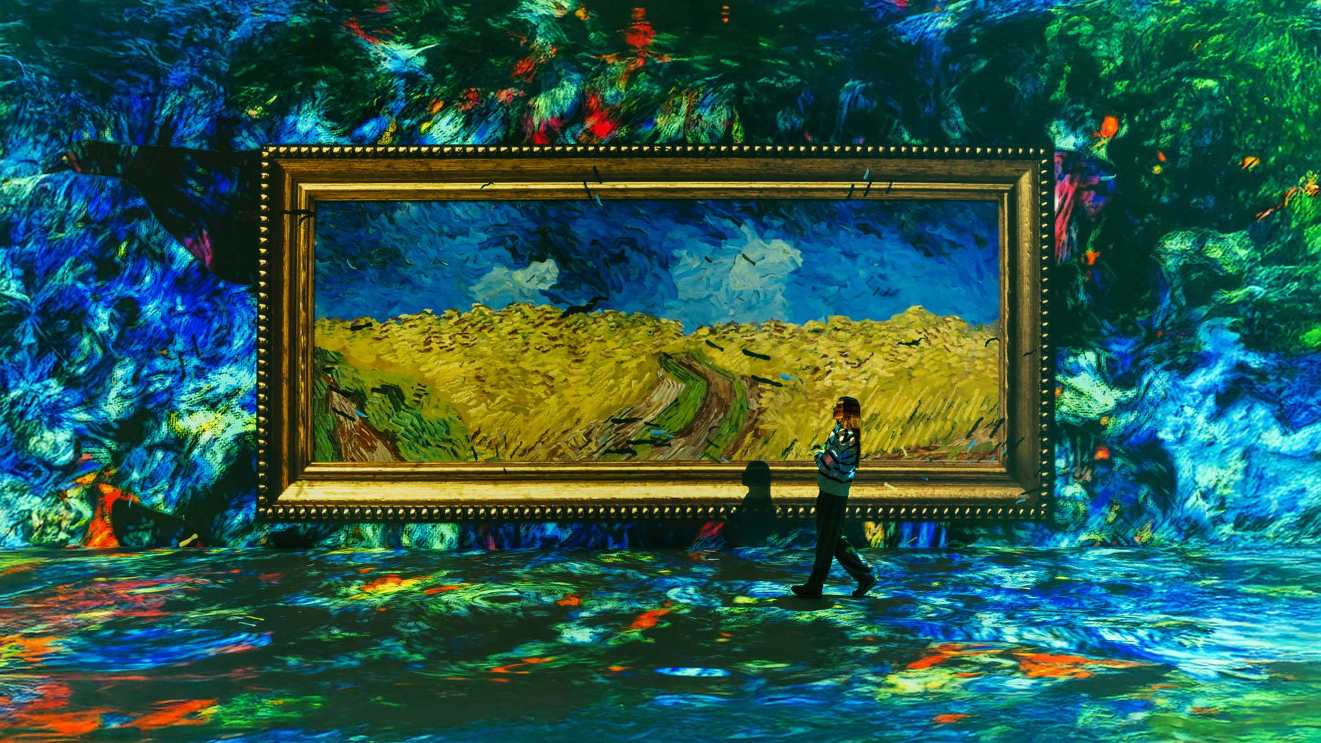 Mujer observando un cuadro de gran formato en una pared iluminada