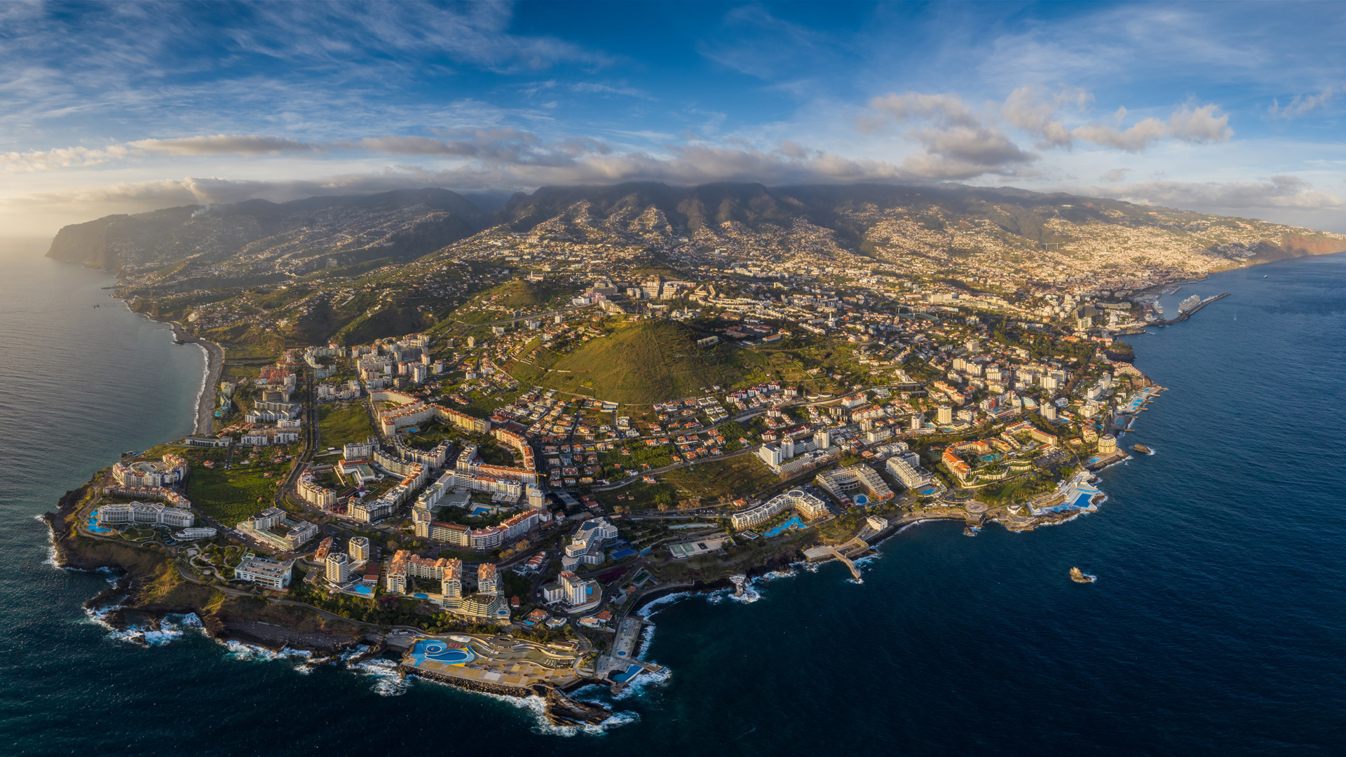 Isla de Madeira con casas y jardines junto al mar.
