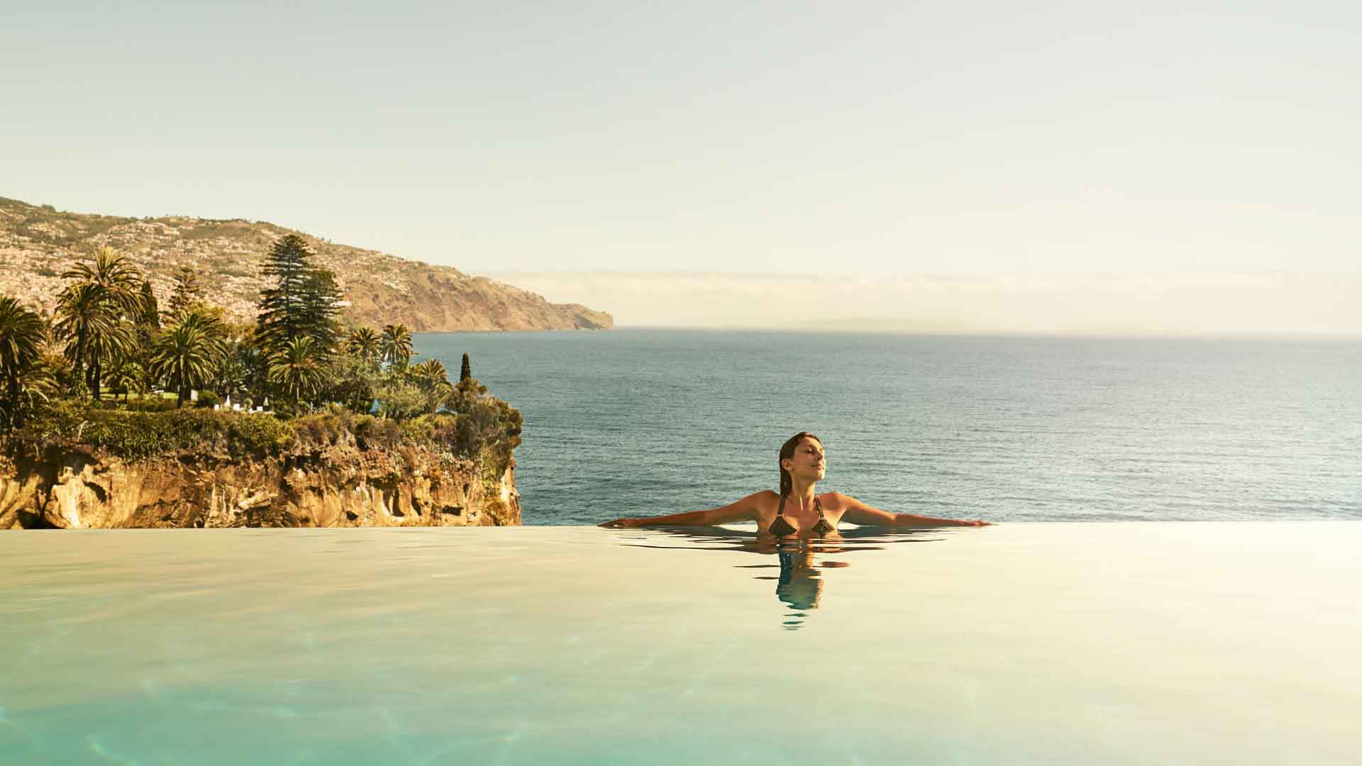 Woman in the infinity pool at PortoBay Hotel on Madeira Island.