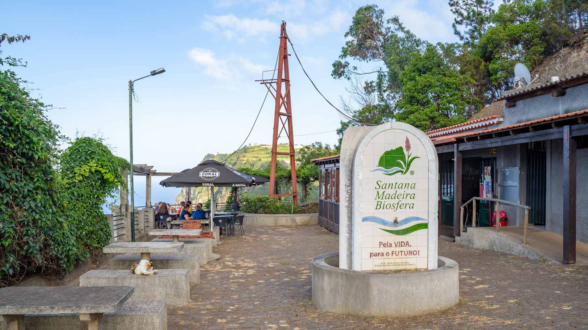 Standorttafel mit Steinbänken neben einem Haus.