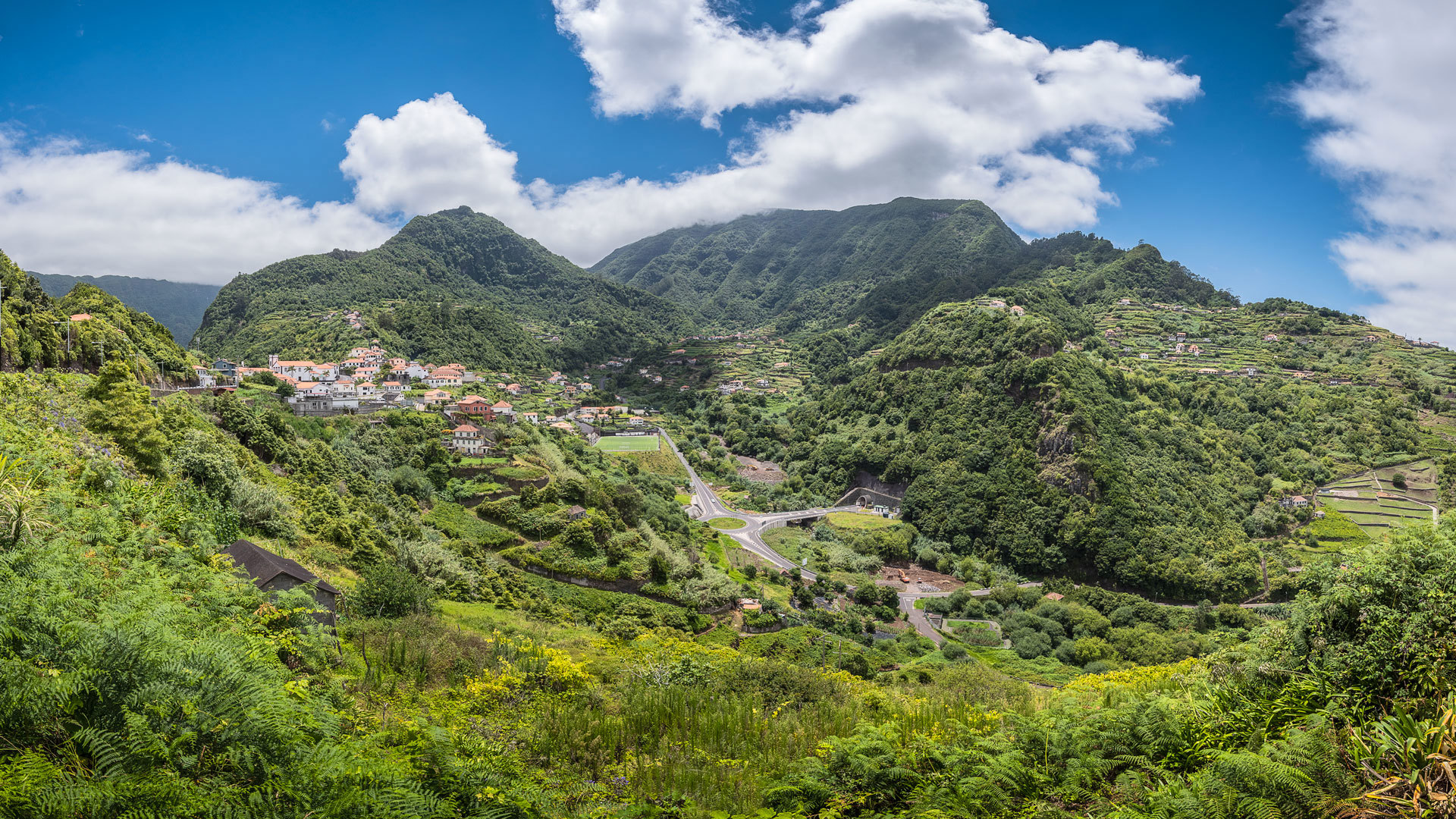 Vale verde com céu e algumas nuvens na Madeira.