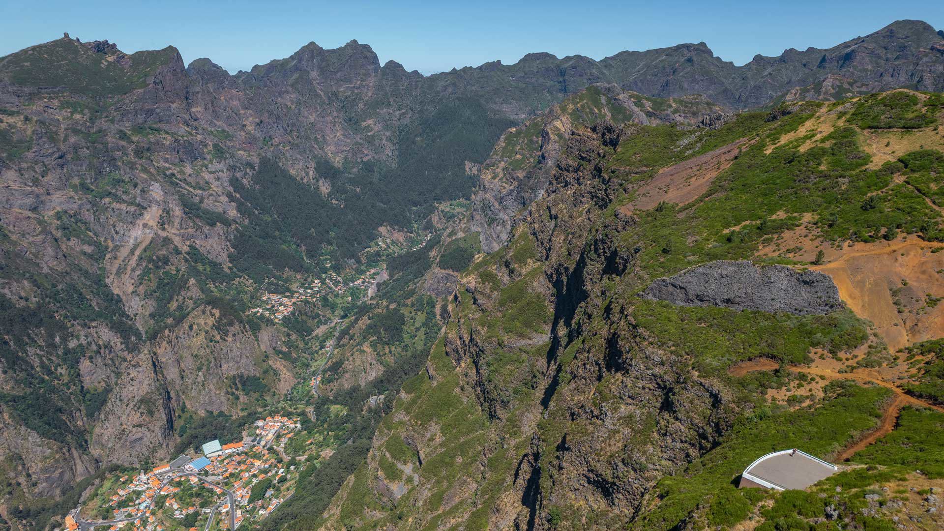 Belvédère du Paredão avec vue sur Curral das Freiras, montagnes, végétation et ciel bleu.