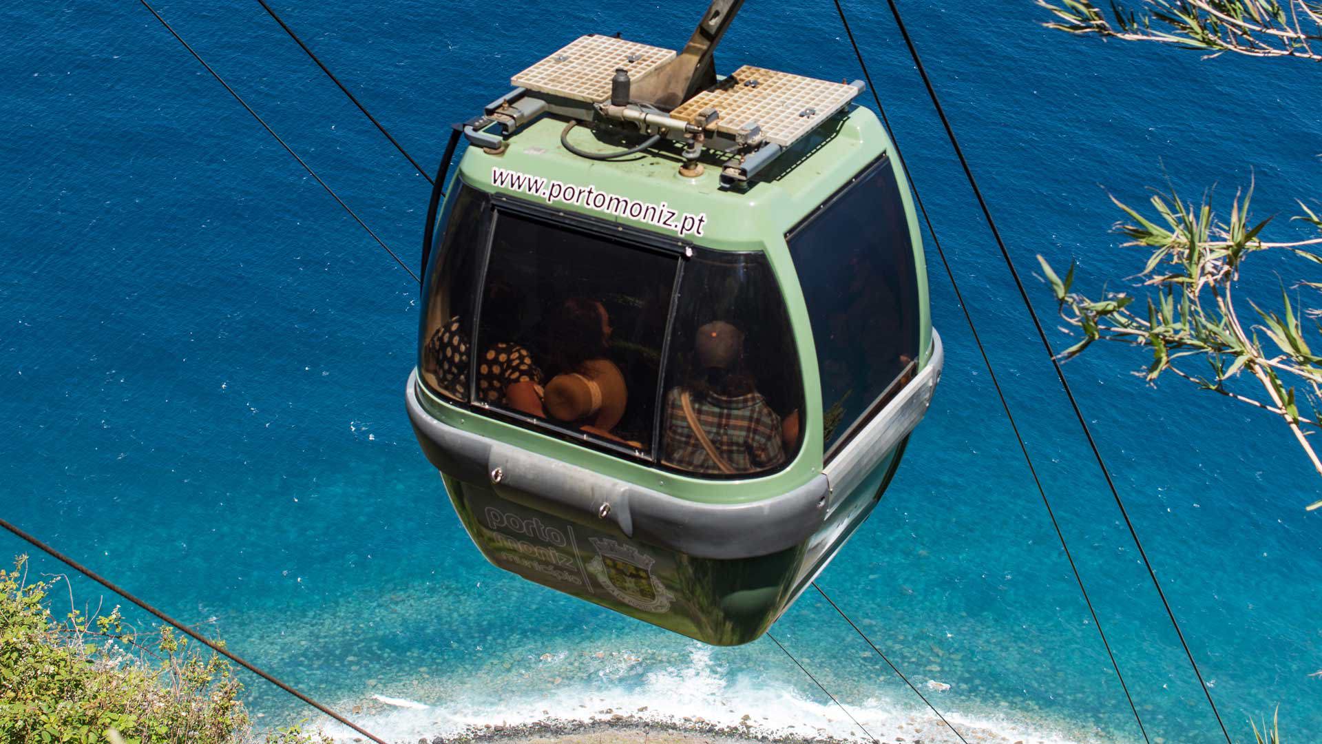 Cabina de teleférico con vista al mar.