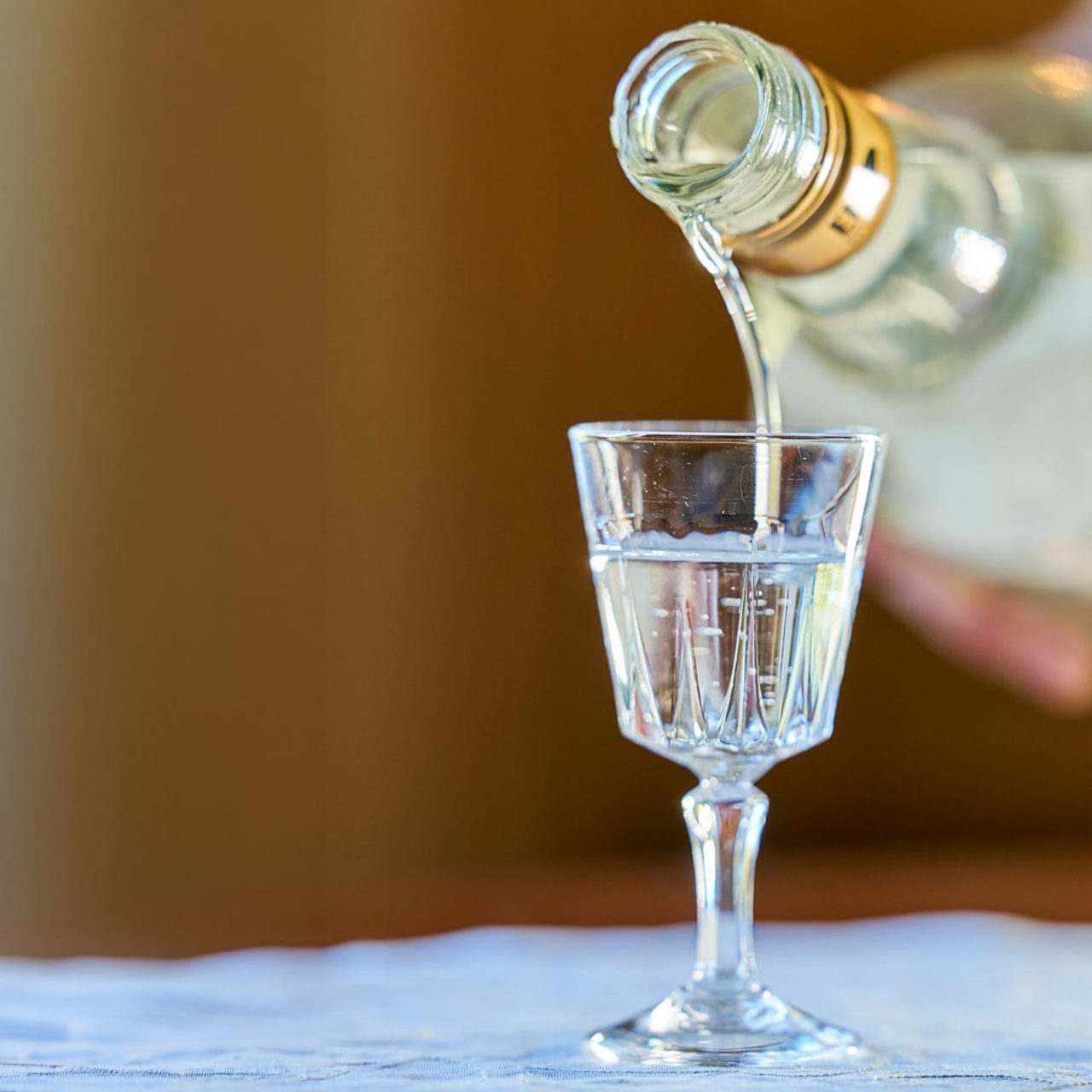 Anise liqueur being poured from a bottle into a glass on Madeira Island.