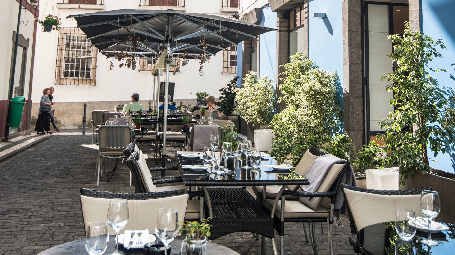 Tables with chairs and umbrellas outdoors.