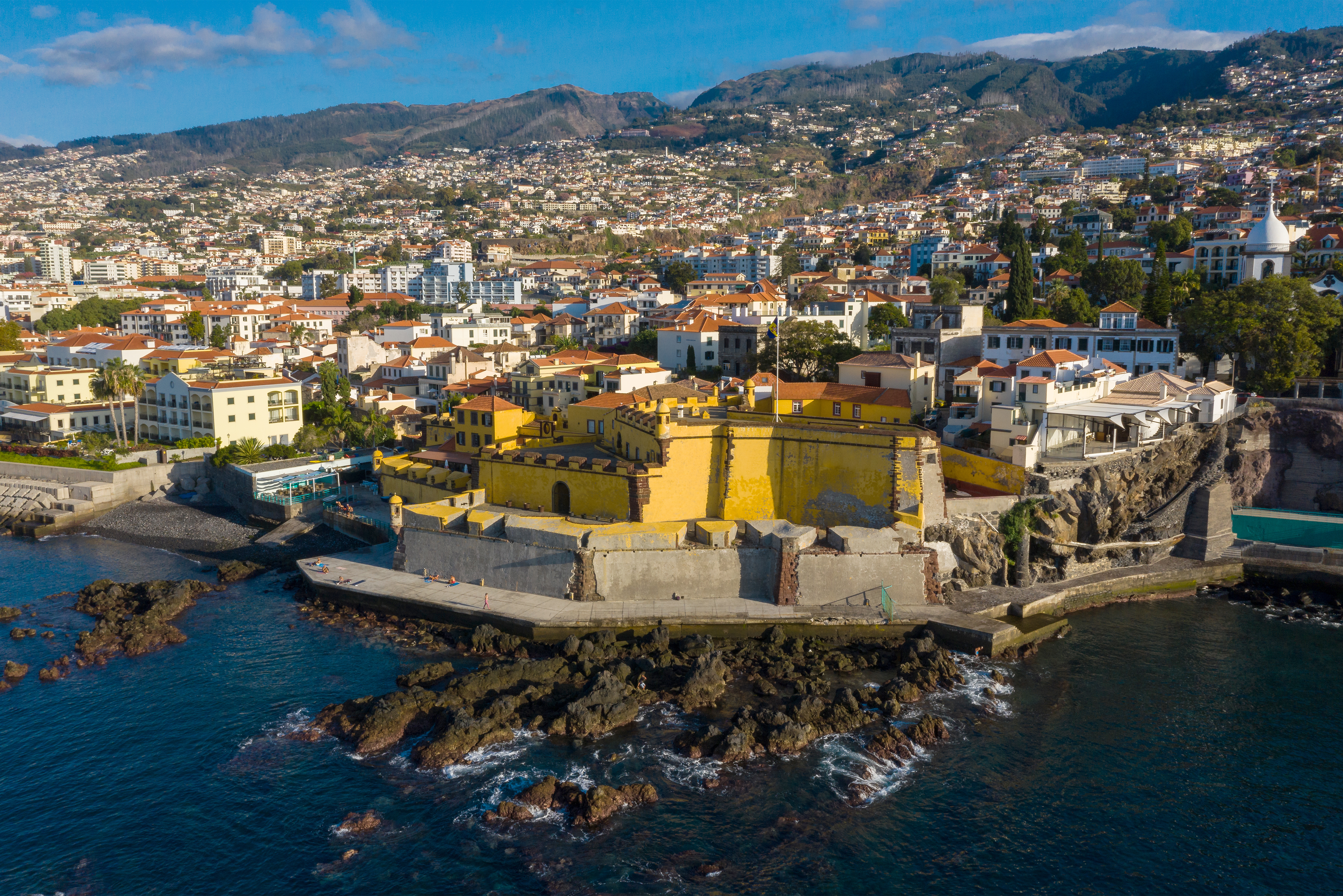 Gelbe Festung neben Häusern und dem Meer auf Madeira.