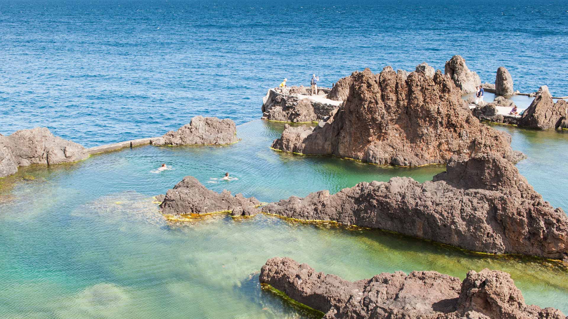 Personas nadando en una piscina natural rodeada de rocas en Madeira.