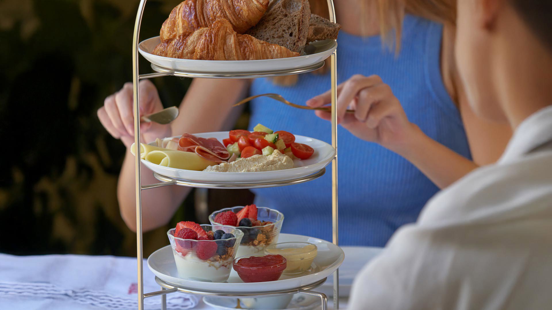 Bolos, frutas e taças de iogurte dispostos por andares na mesa da Choux Pâtisserie.