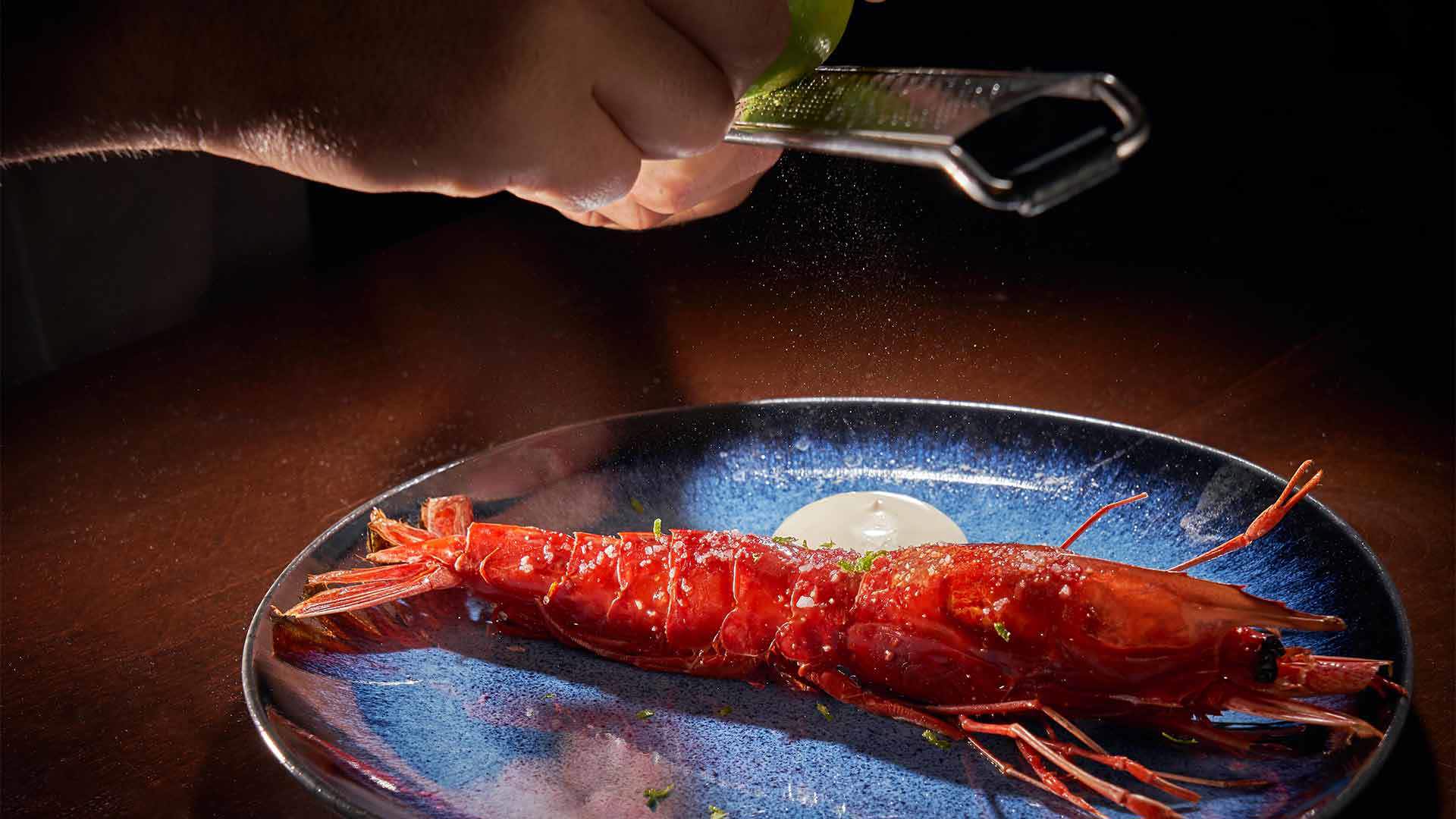 Assiette avec gambas et un peu de sauce.