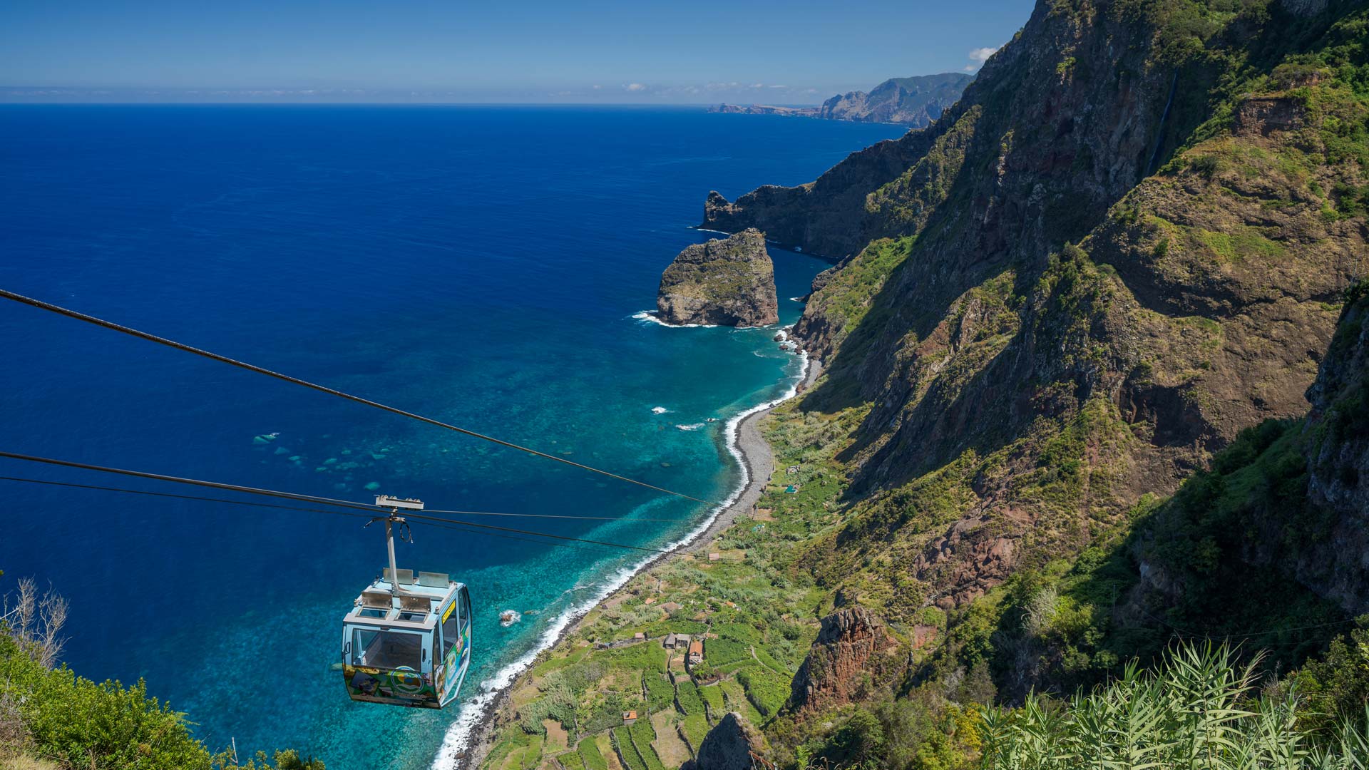 Teleférico a descer a encosta em direção ao mar na Madeira.